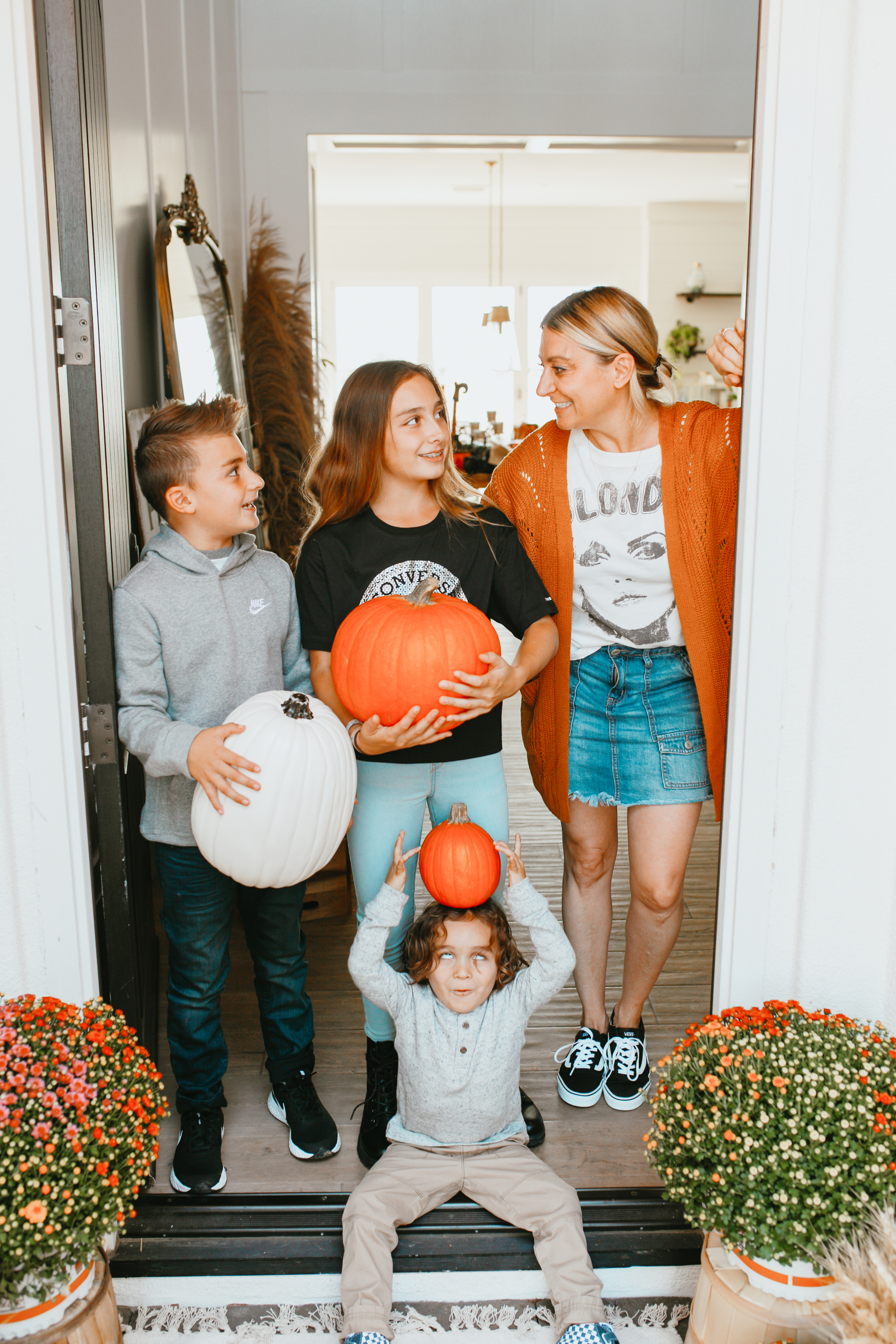 mom and kids holding pumpkins
