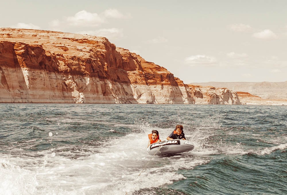 boys on inner tube on a lake