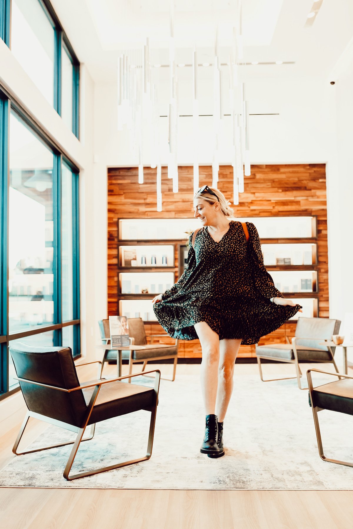 A woman walks through a medical spa lobby while playing with her dress.