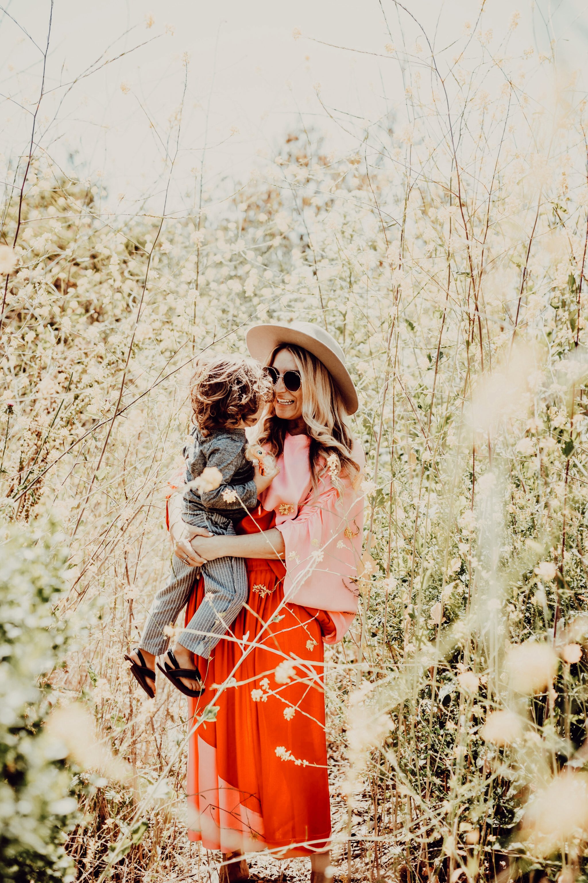 mom and baby standing in a flower field 