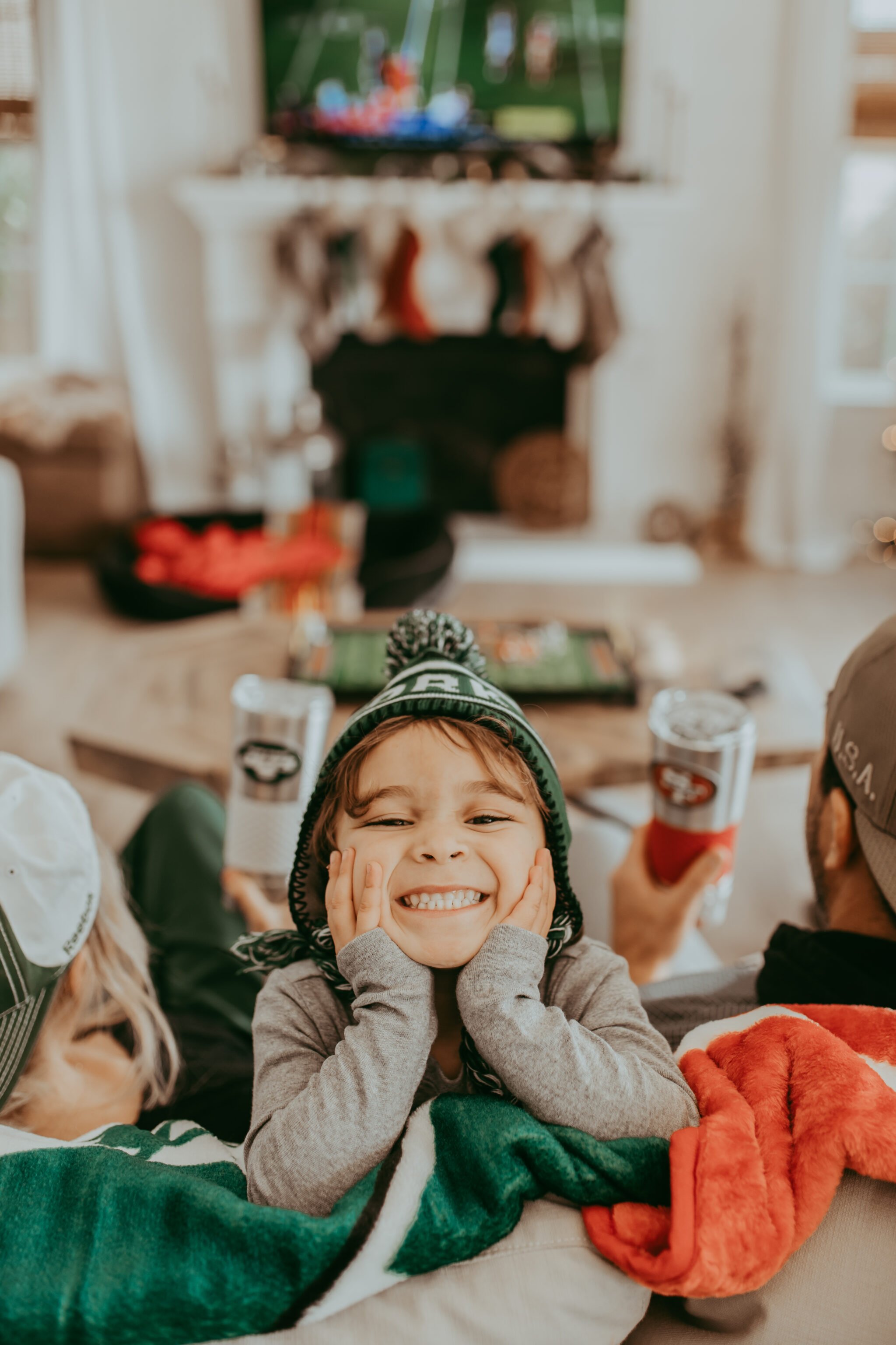 parents and toddler watching football