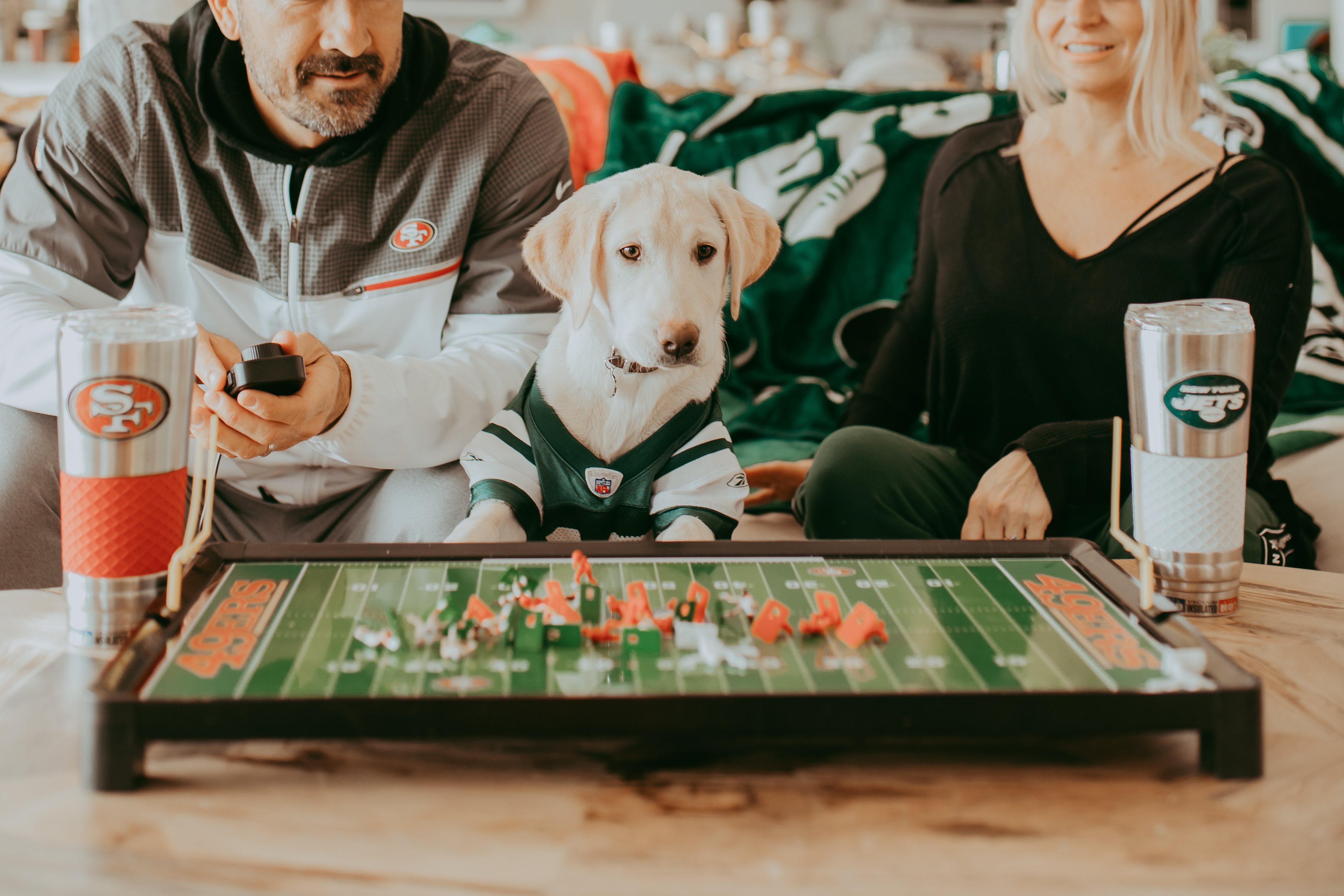 couple watching football with their dog