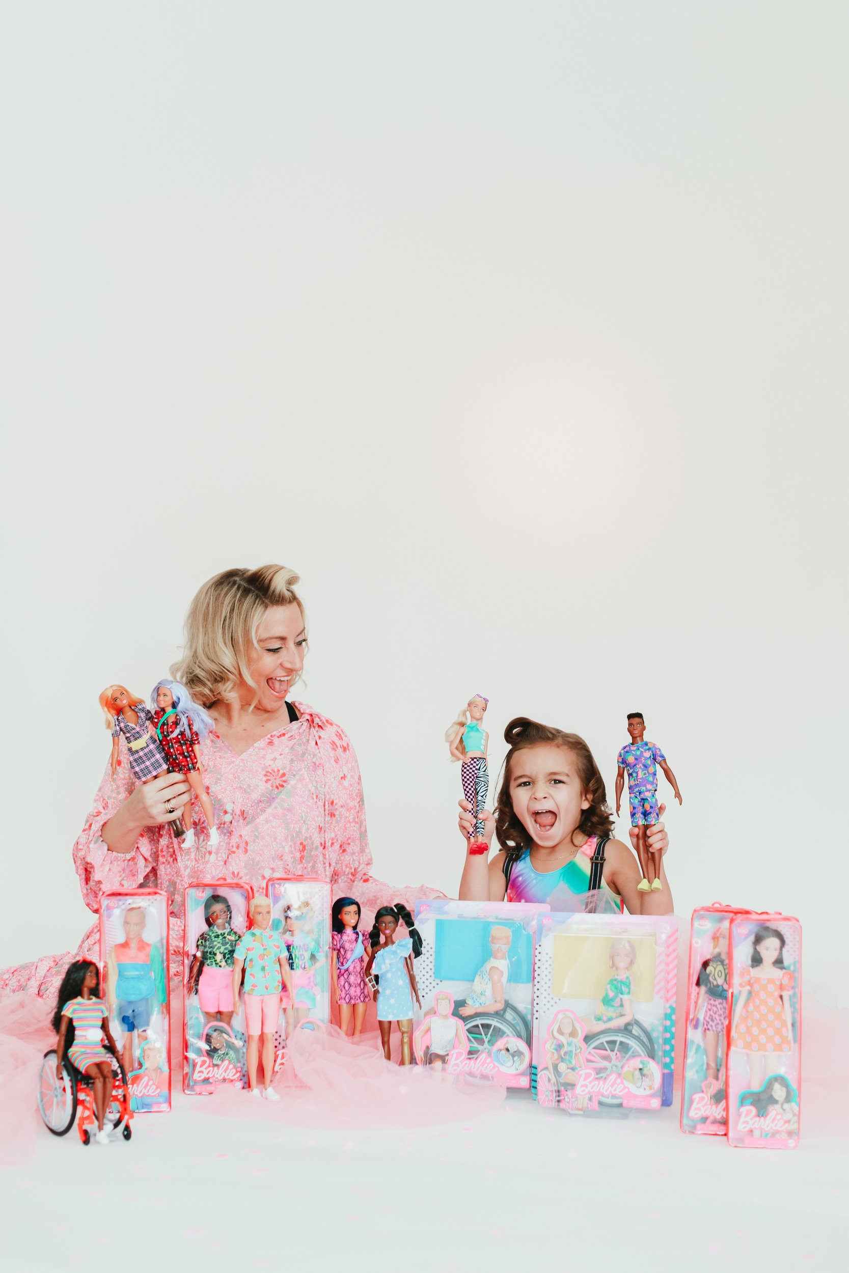 mom and kid playing with barbie dolls