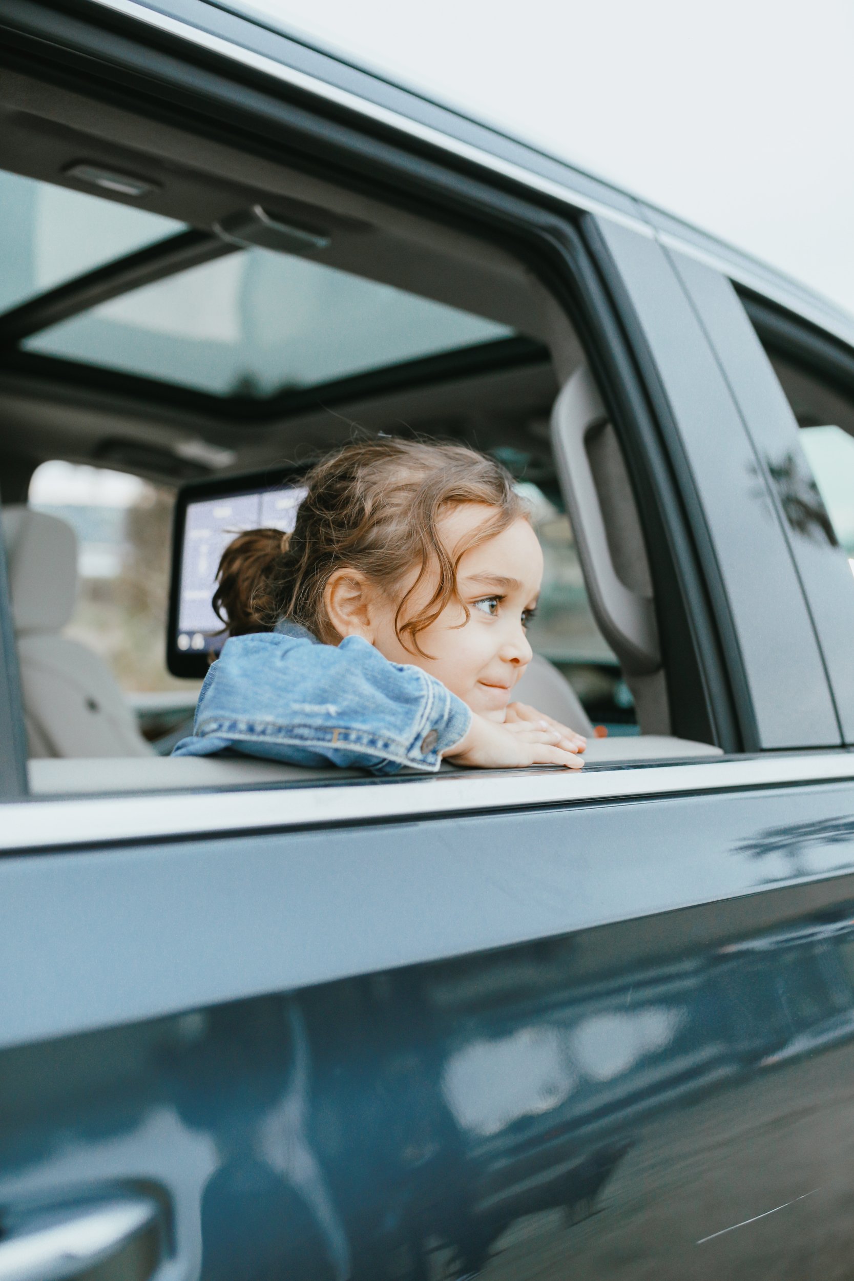 boy looking out window of car