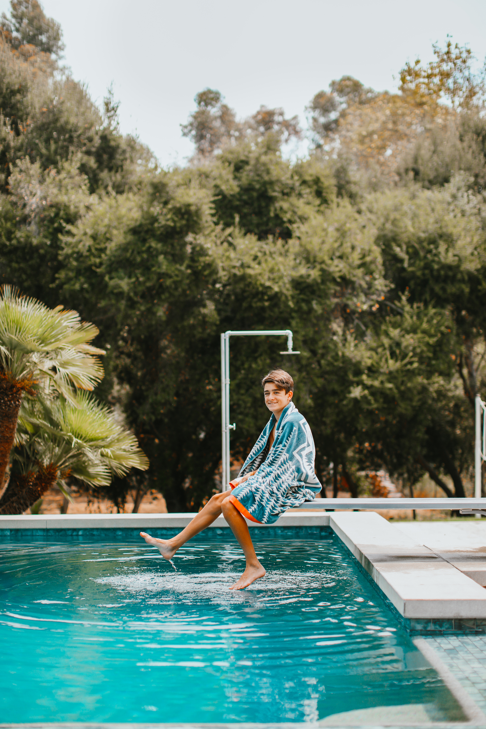 boy sitting on diving board