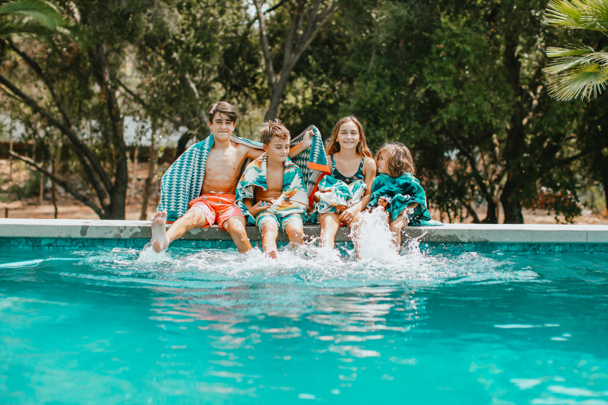 kids sitting on edge of pool