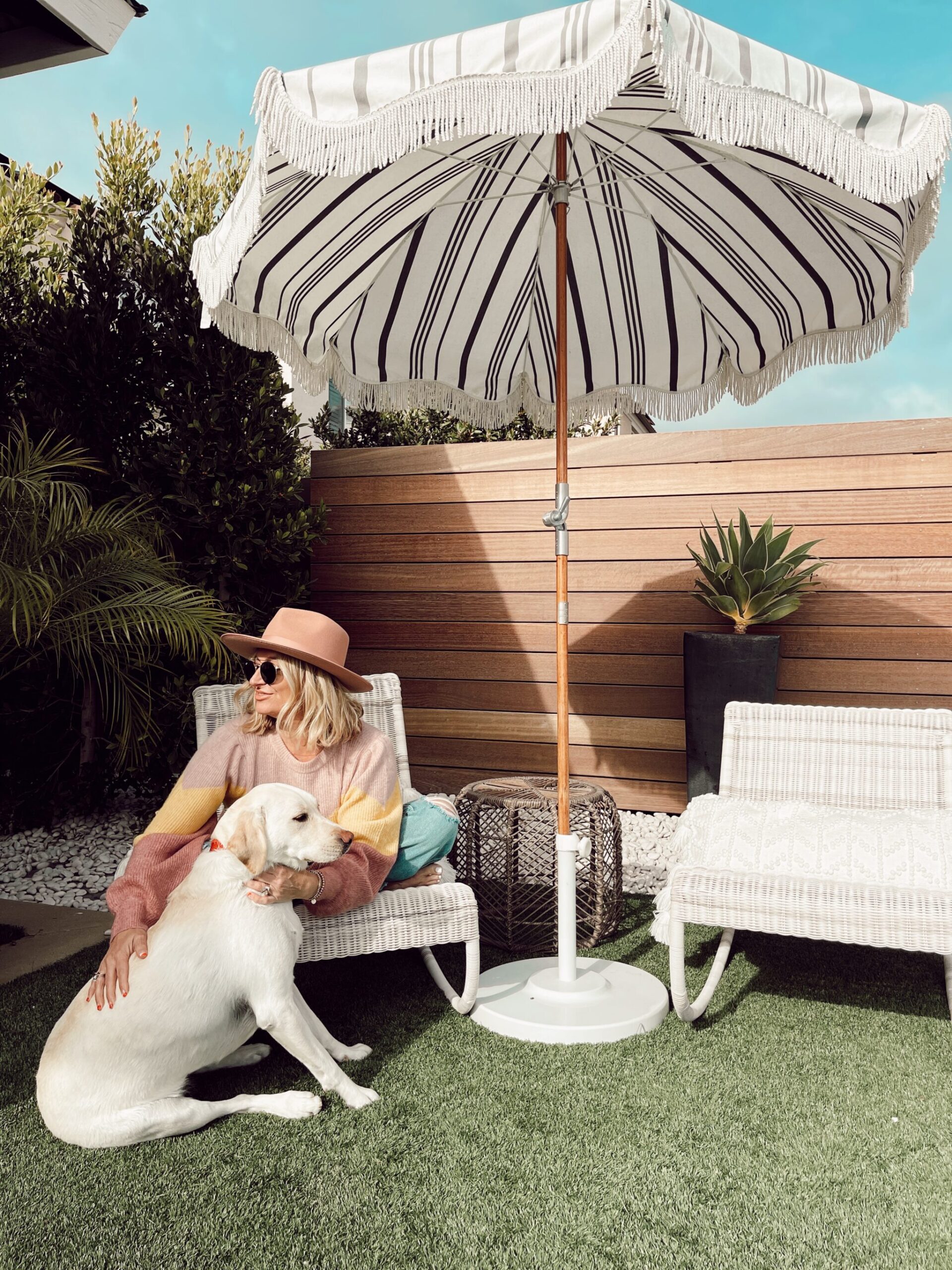 woman sitting outside with her dog enjoying seasonal sunshine