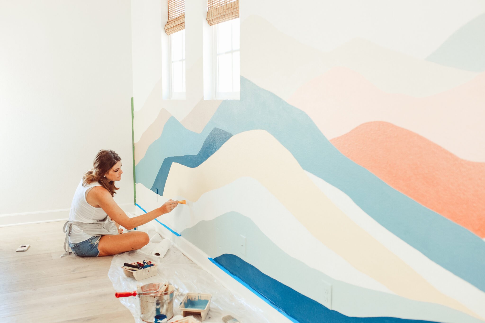 woman painting wall mural