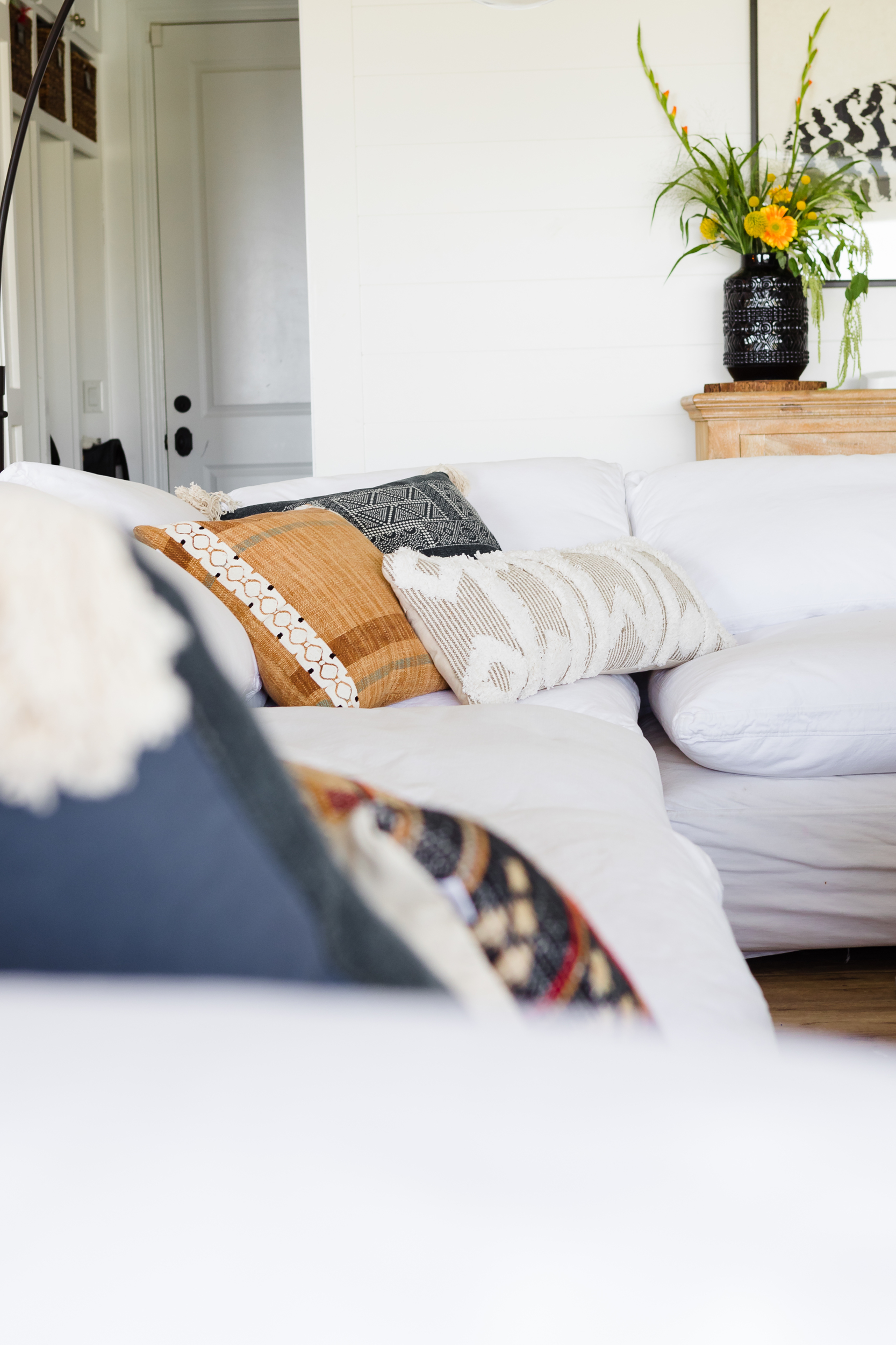 Neutral throw pillows sitting on a white couch.