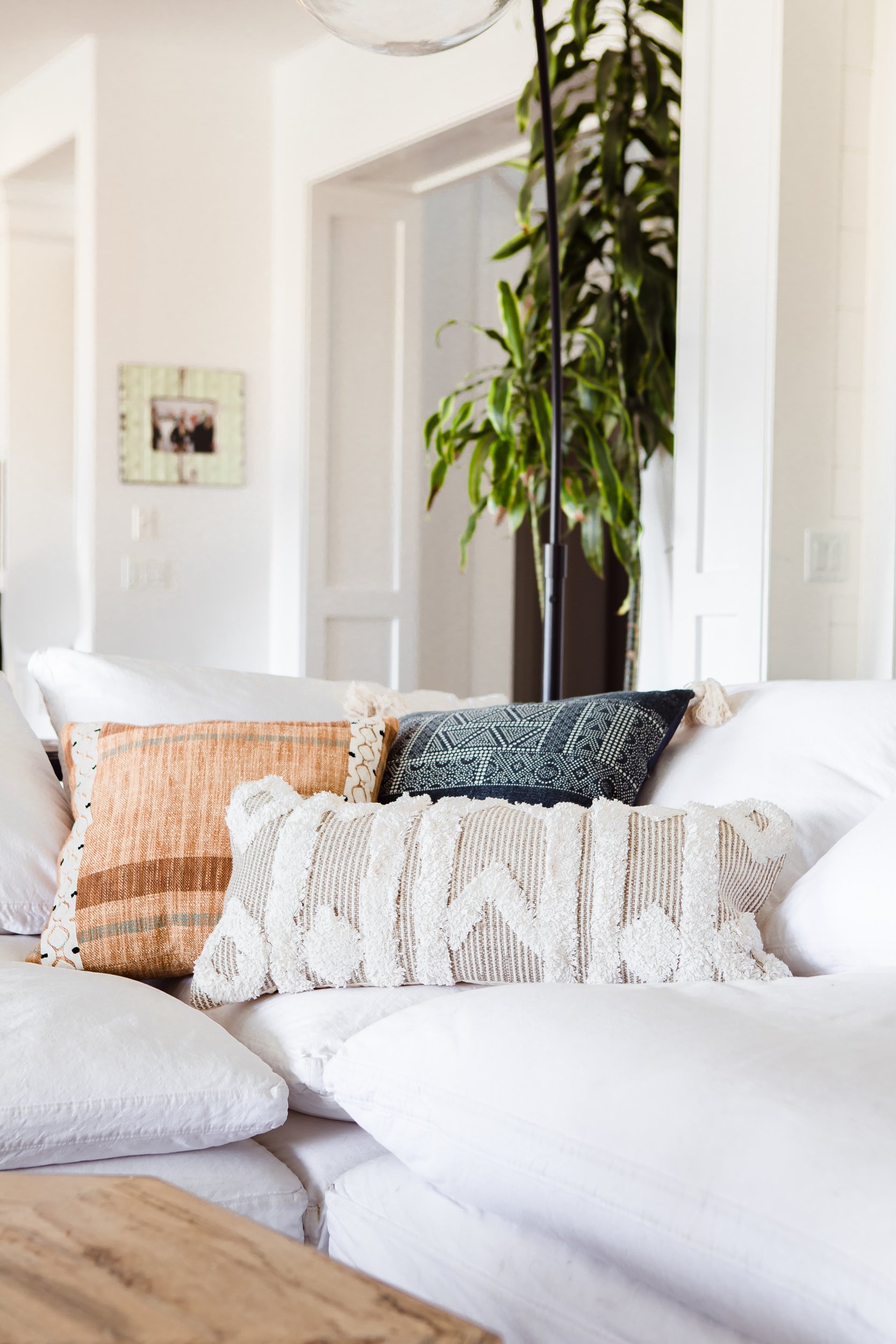 Multicolored throw pillows sitting on the corner of a sectional sofa.