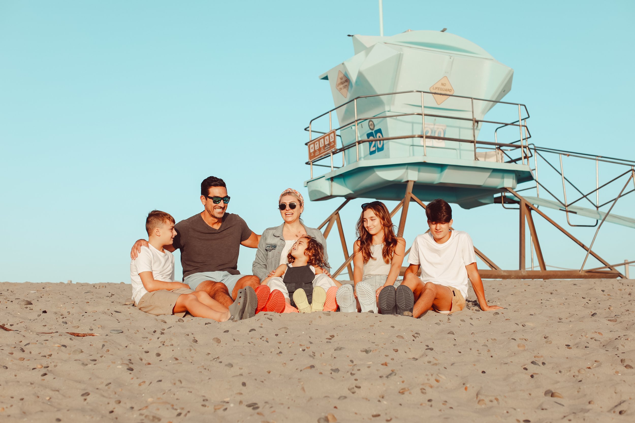 family sitting together on the beach