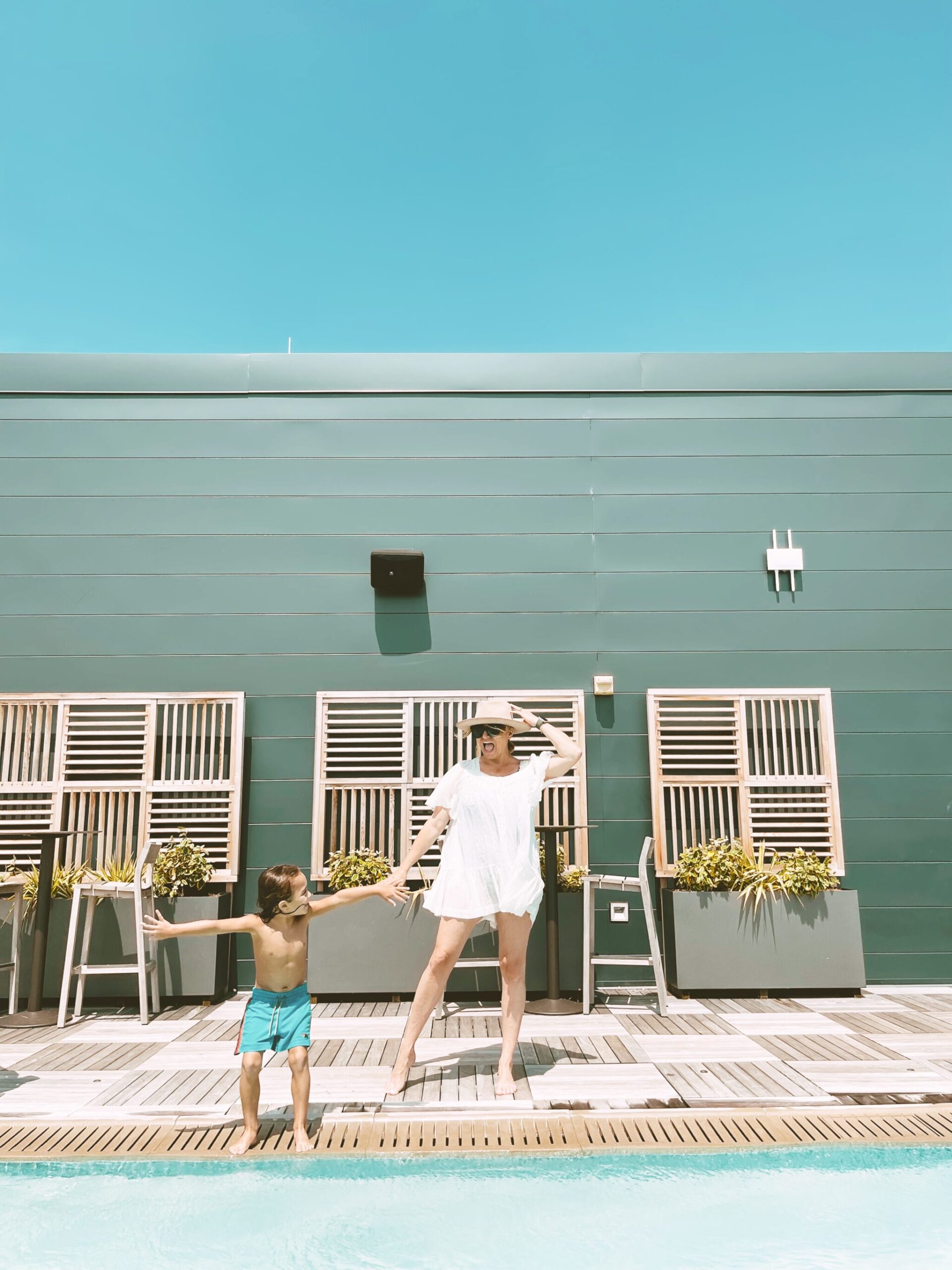 mom and son dancing around pool