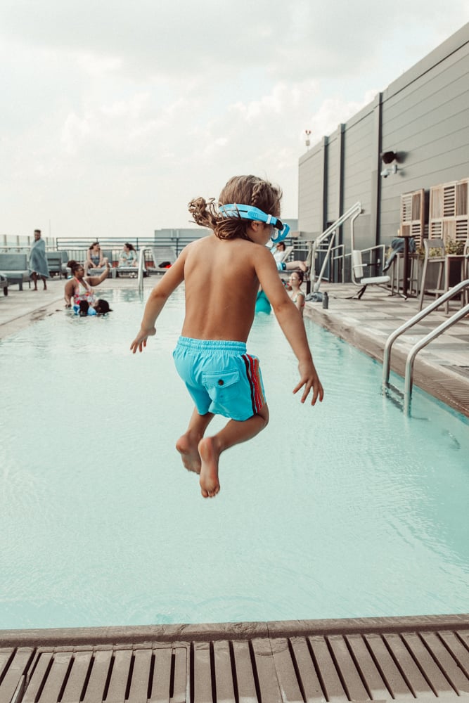 boy jumping into pool