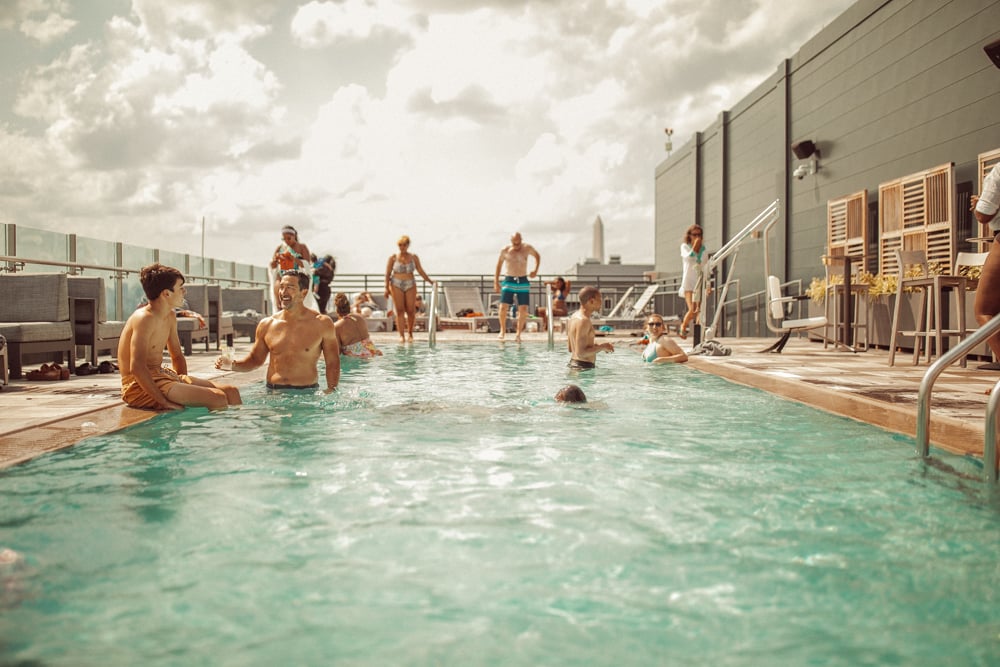 family in rooftop pool