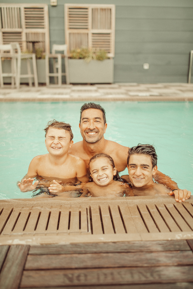 dad with three sons in pool