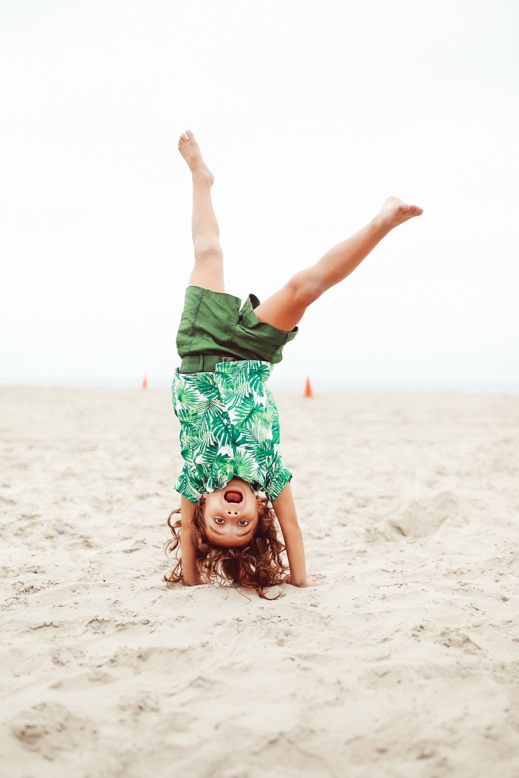 boy doing a cartwheel in the sand