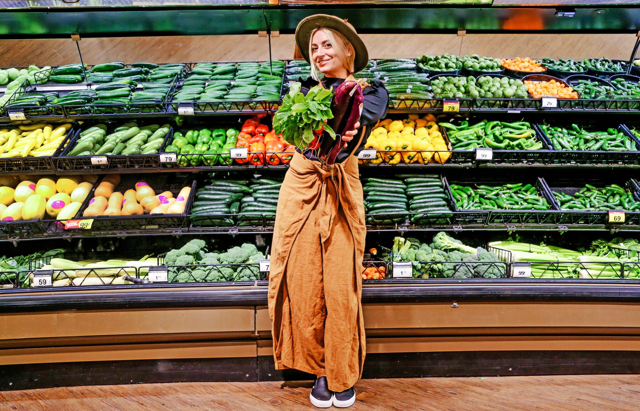 woman standing in grocery store vegetable aisle 