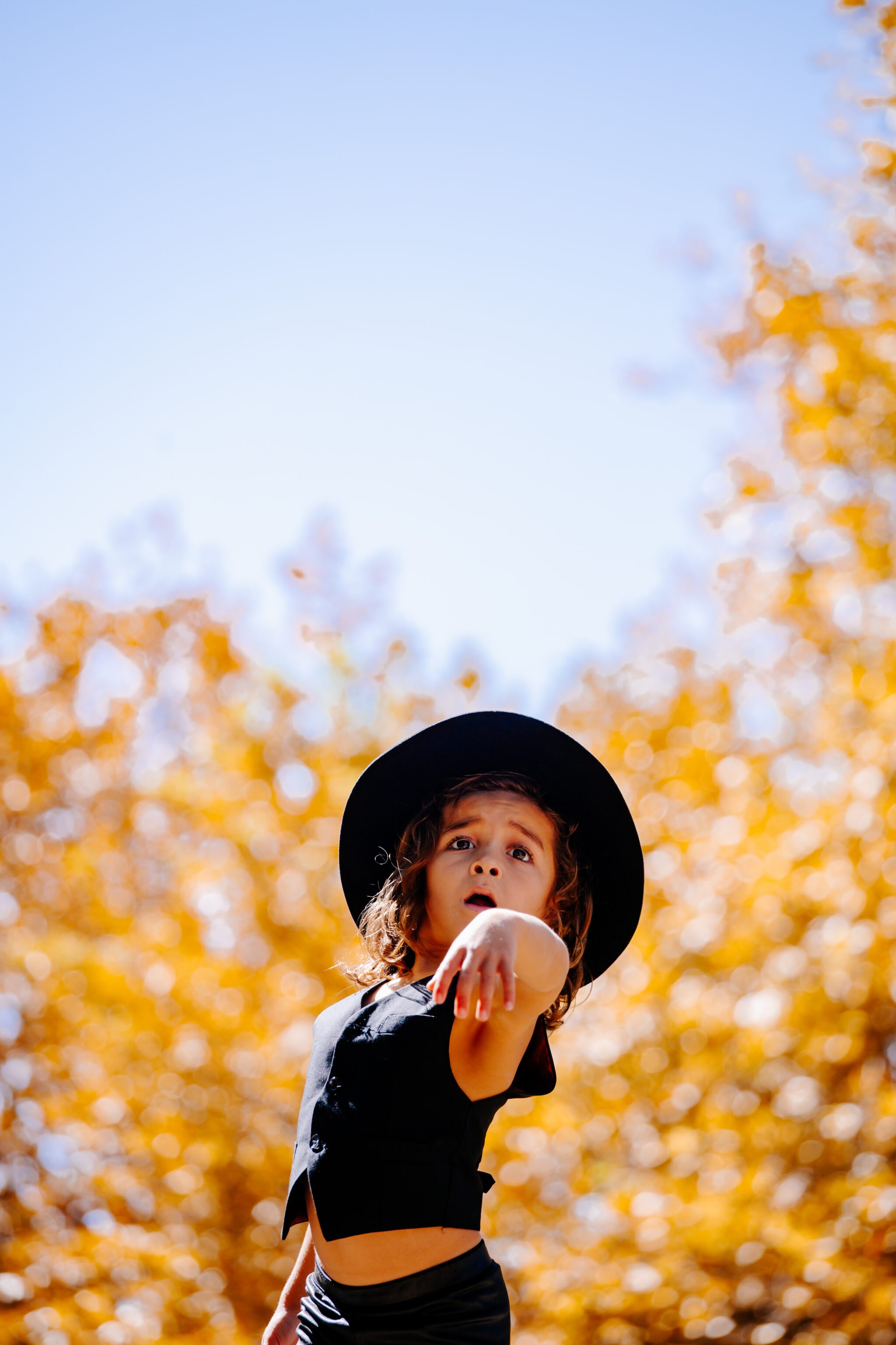 boy dancing in fall leaves