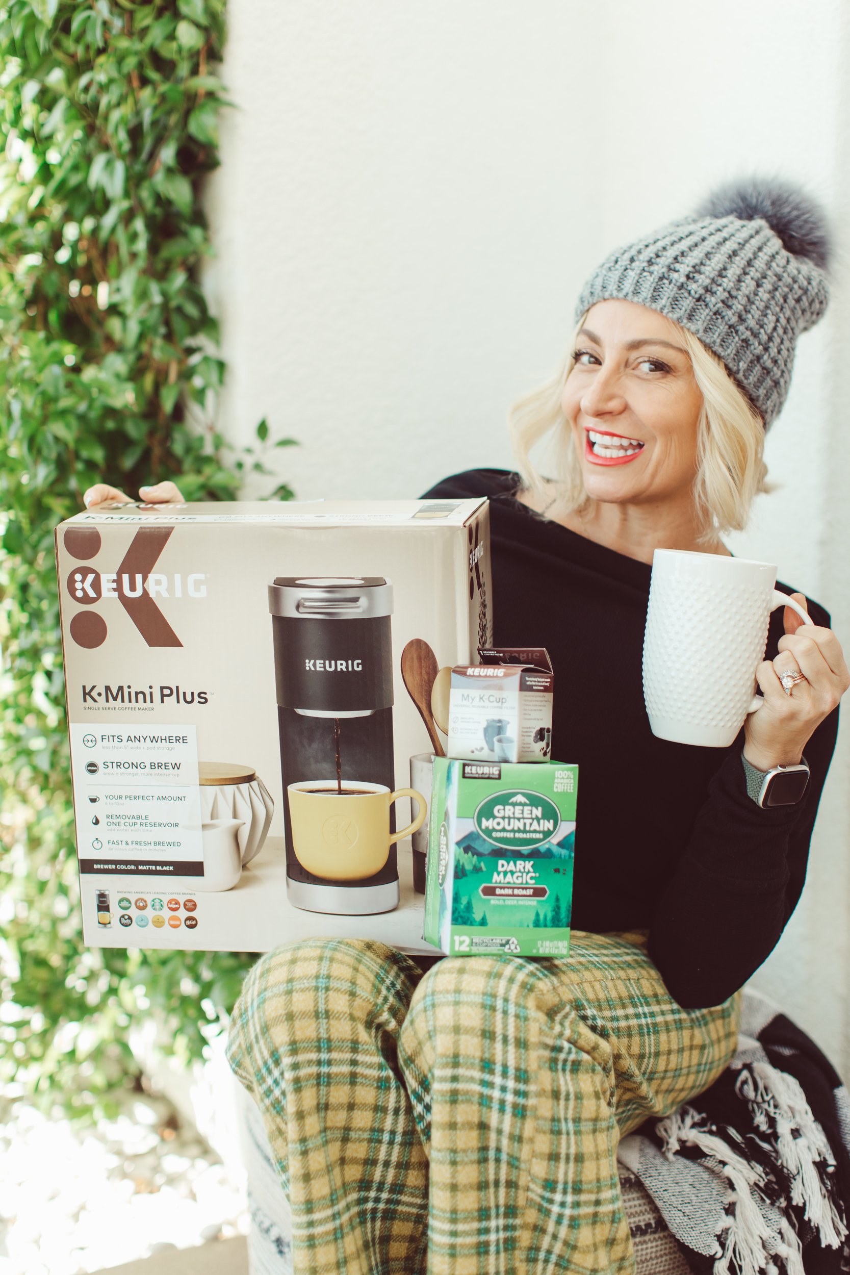 woman holding a coffee maker drinking coffee