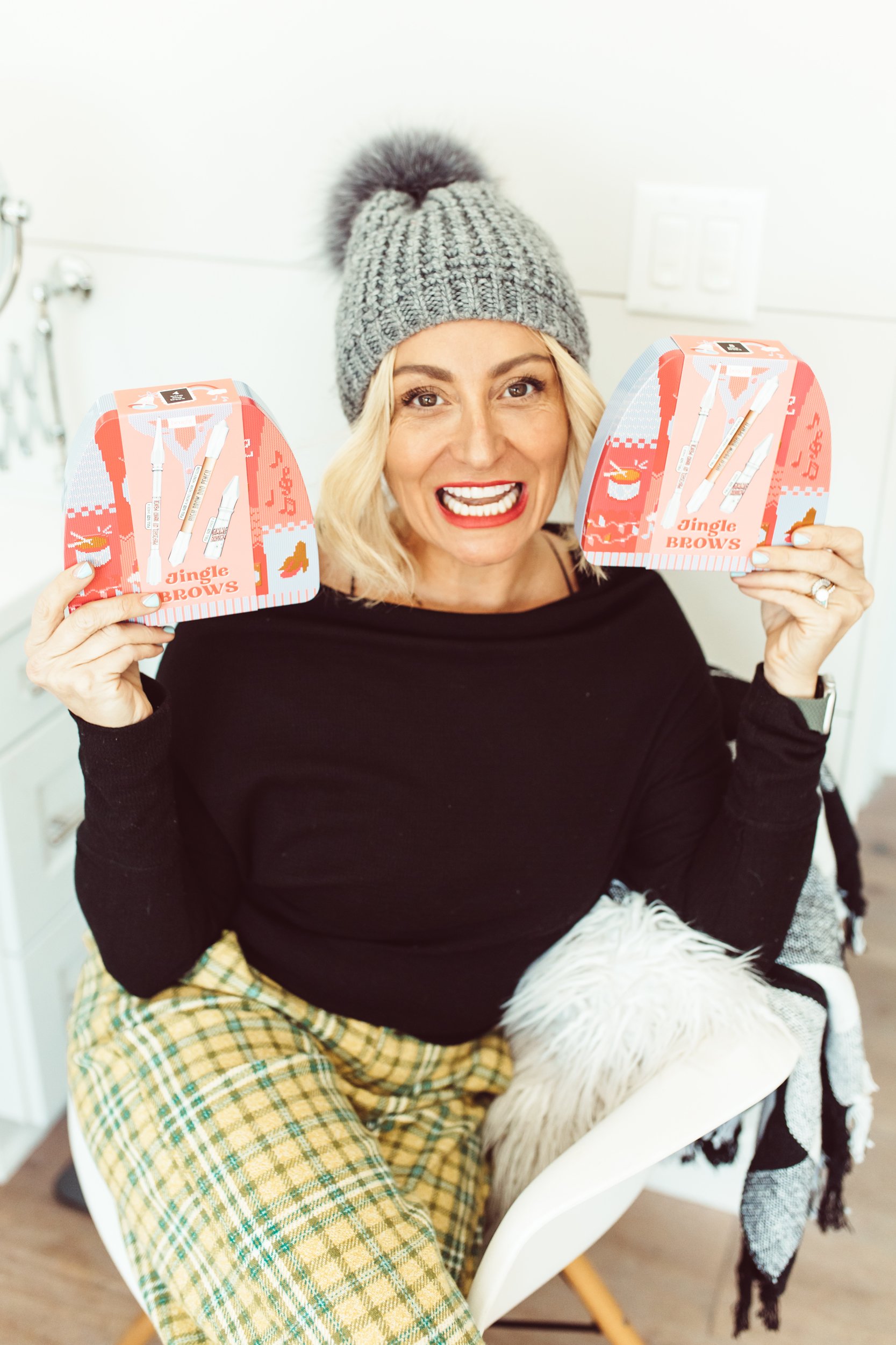 woman holding up cosmetic boxes