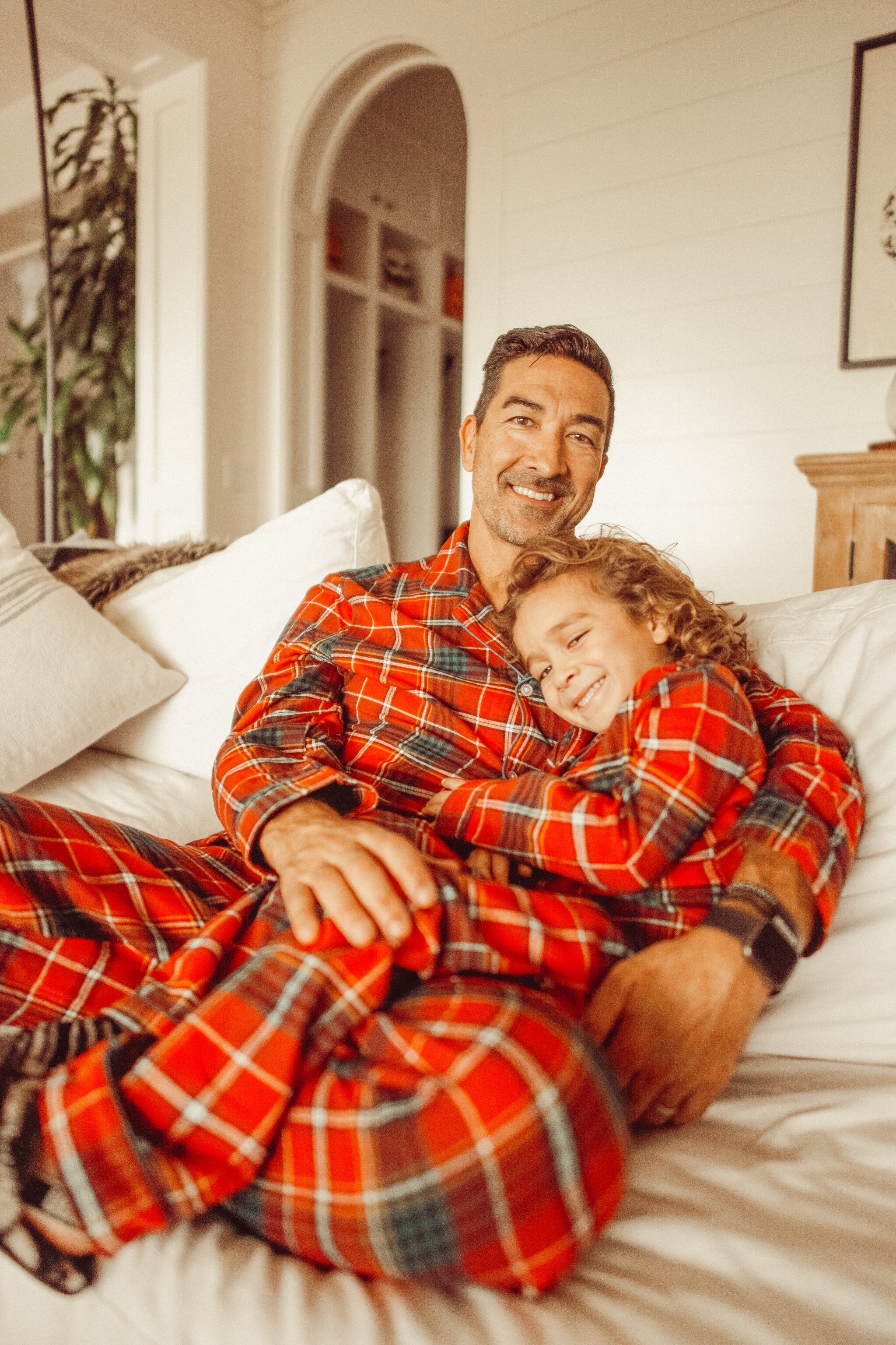 father and son on the couch in matching pajamas