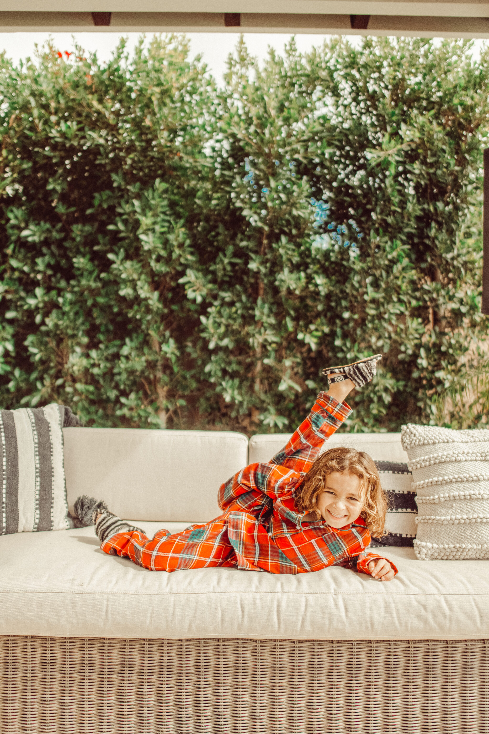 boy dancing in christmas pajamas on couch