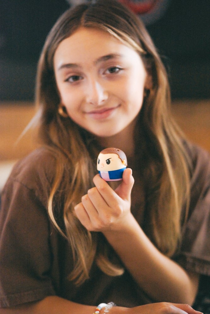 girl holding tiny bluetooth speaker