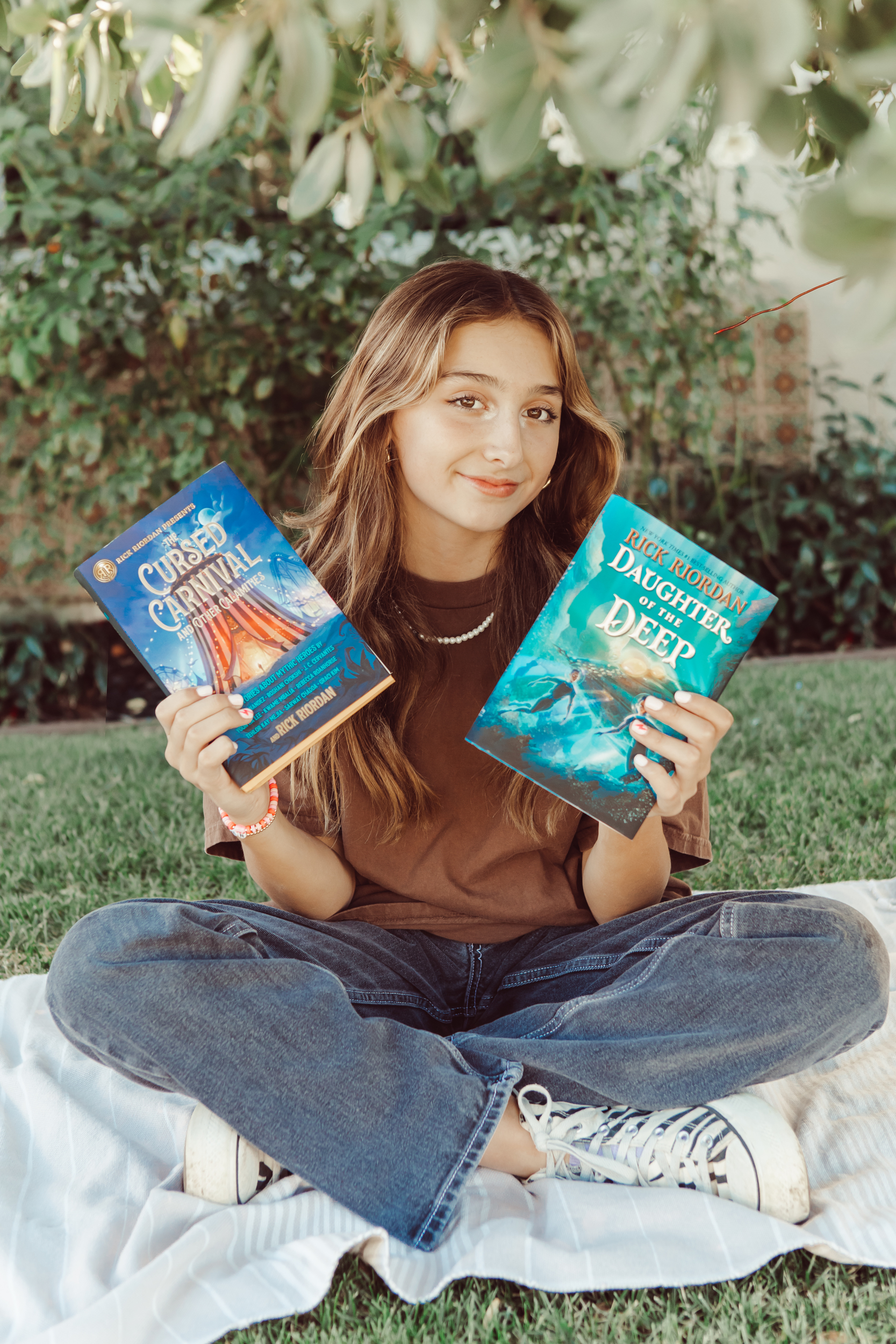 girl holding up two books