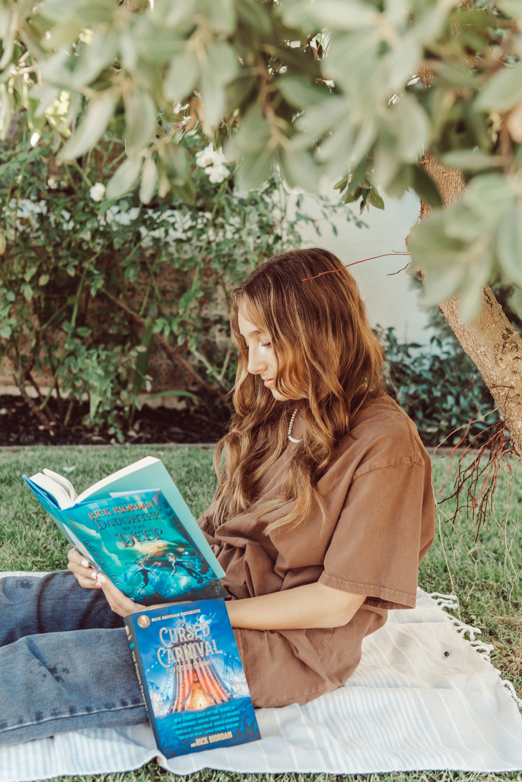 girl reading under a tree