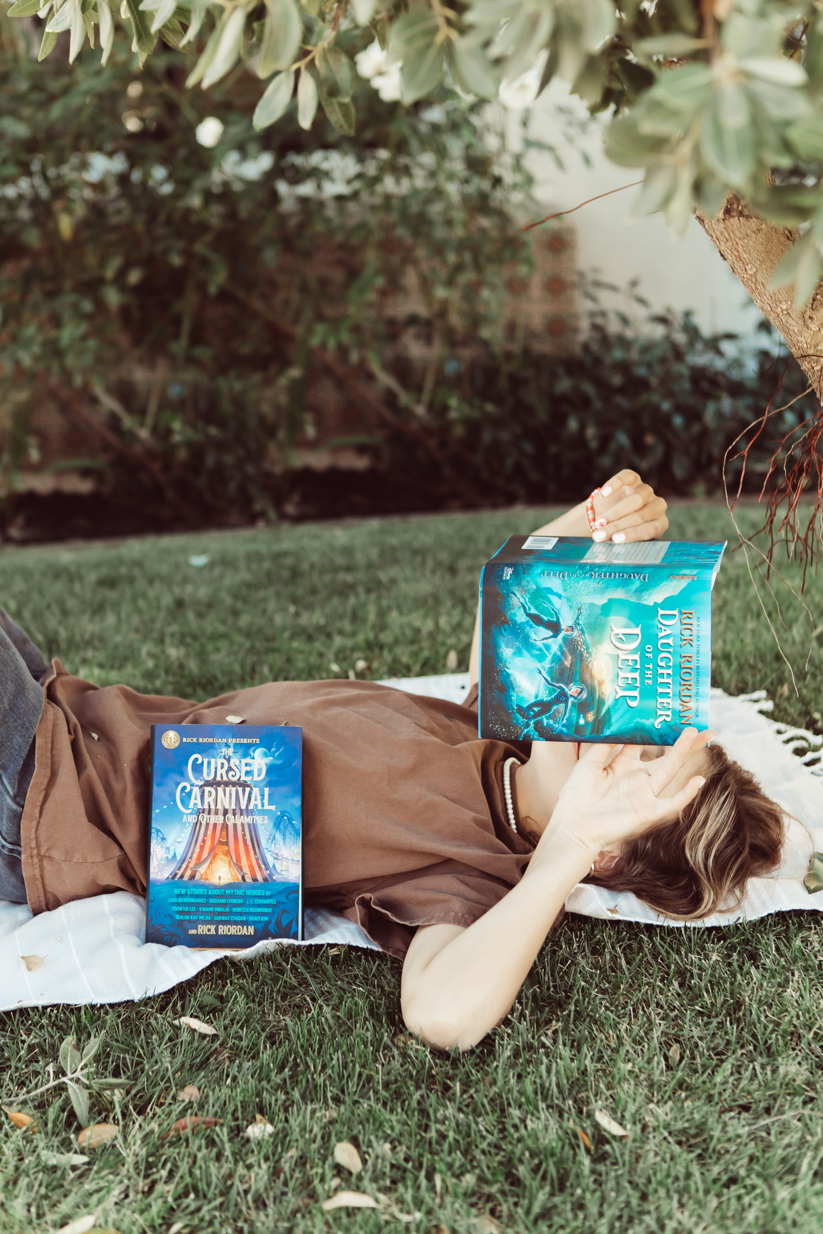 girl lying on the grass reading books