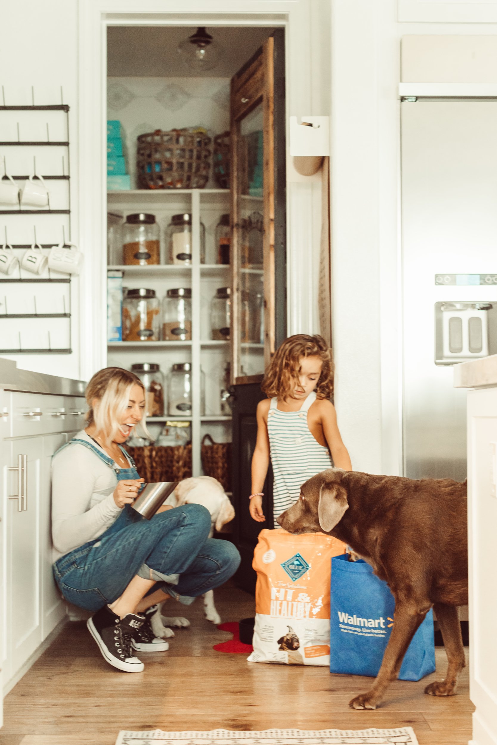 mom and son feeding dog in the kitchen
