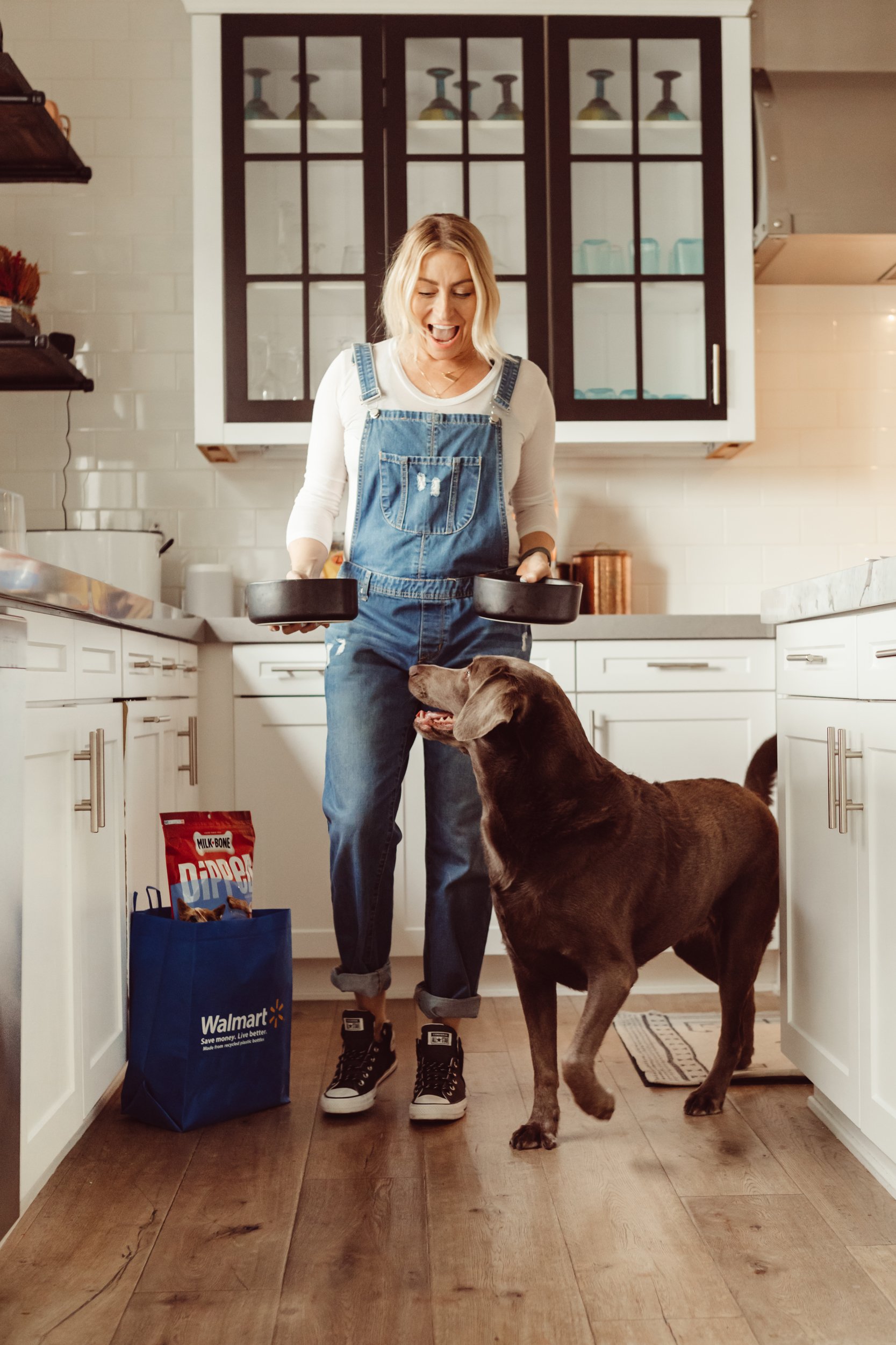 woman feeding her dog in the kitchen