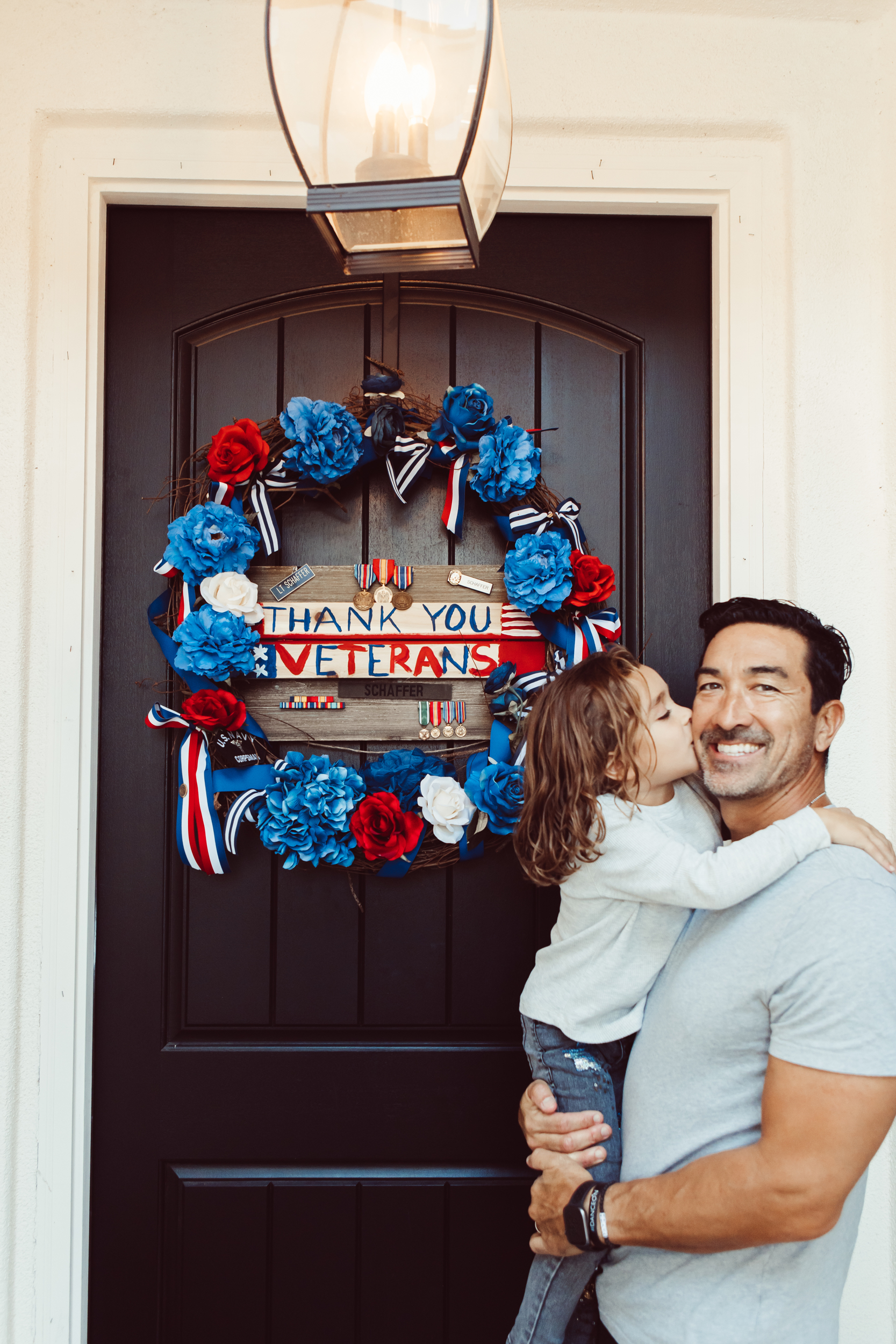 toddler kissing dad by front door