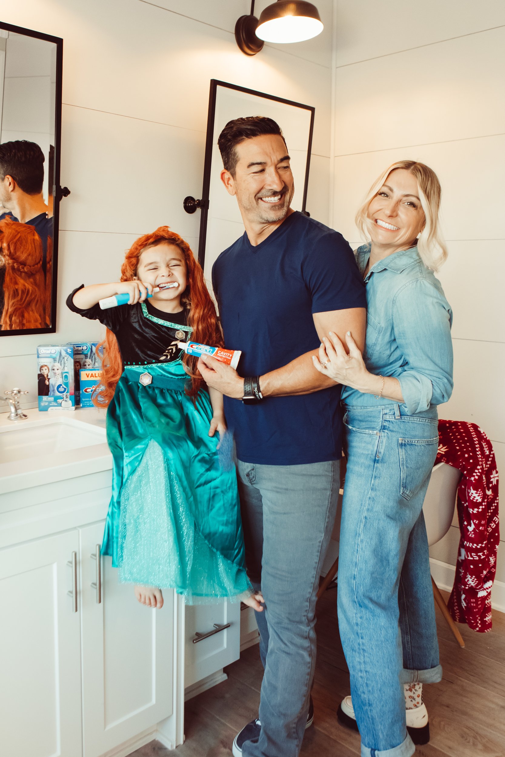 parents with child brushing their teeth