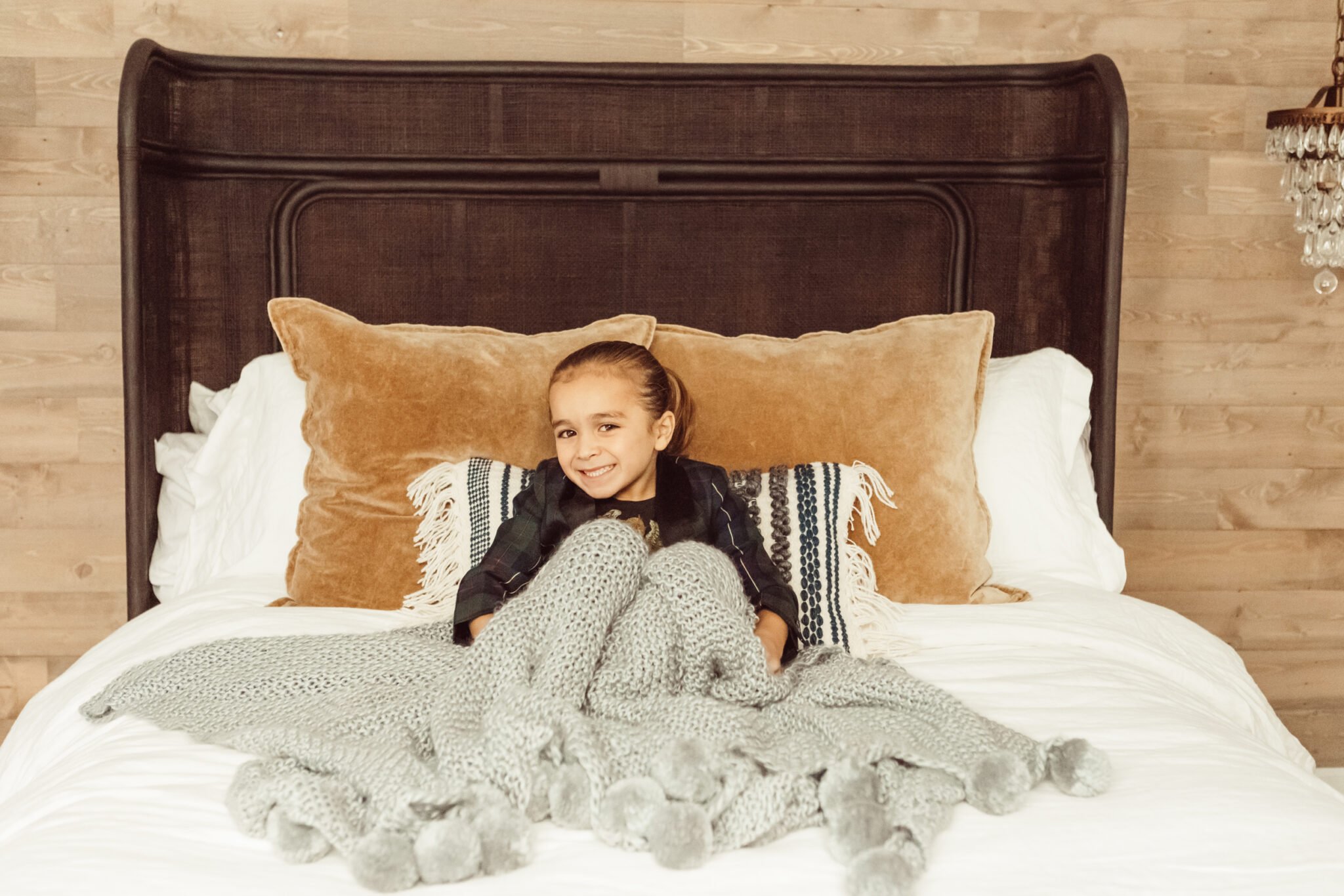 boy sitting on bed with pillows