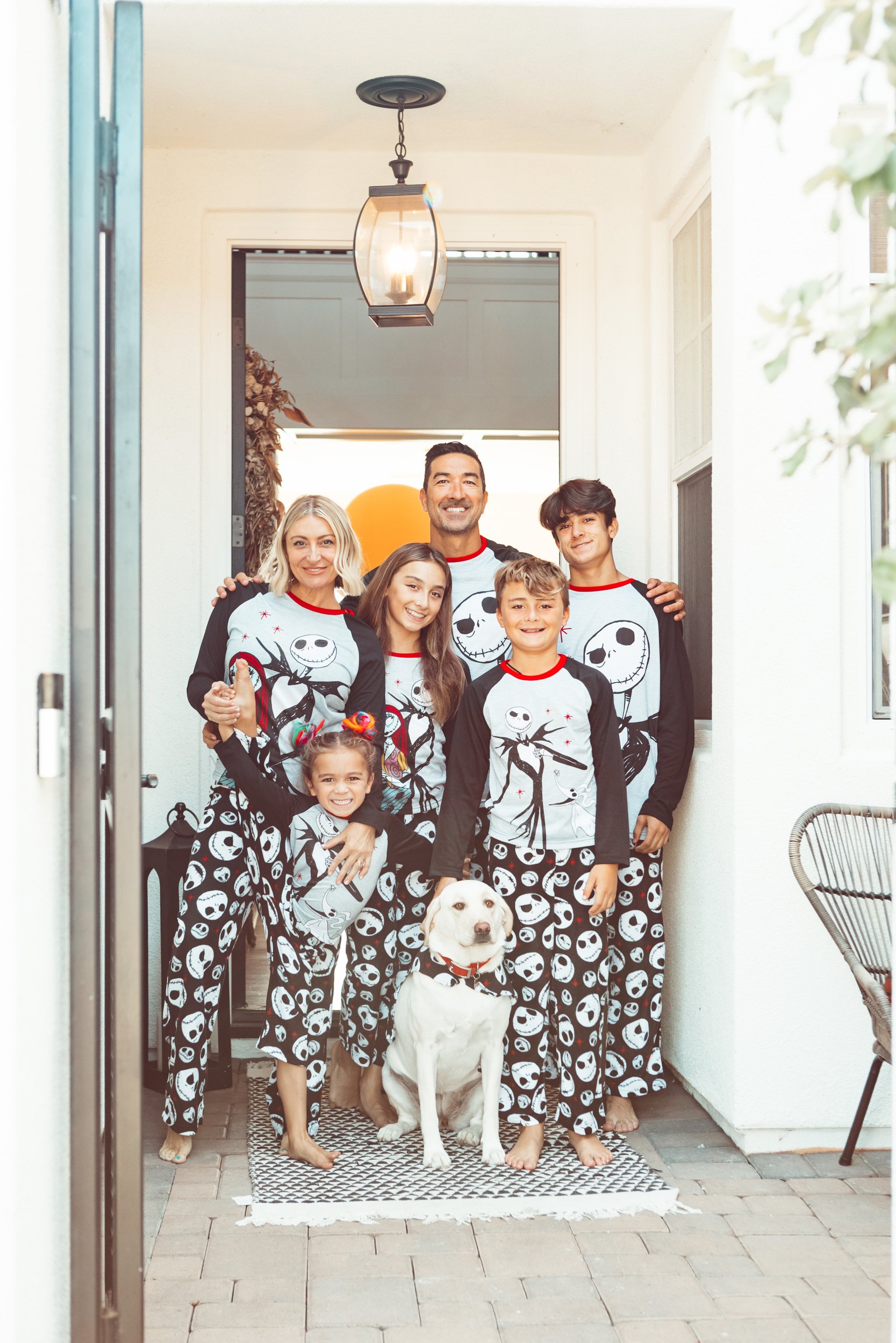 family with pumpkin and dog in matching pjs