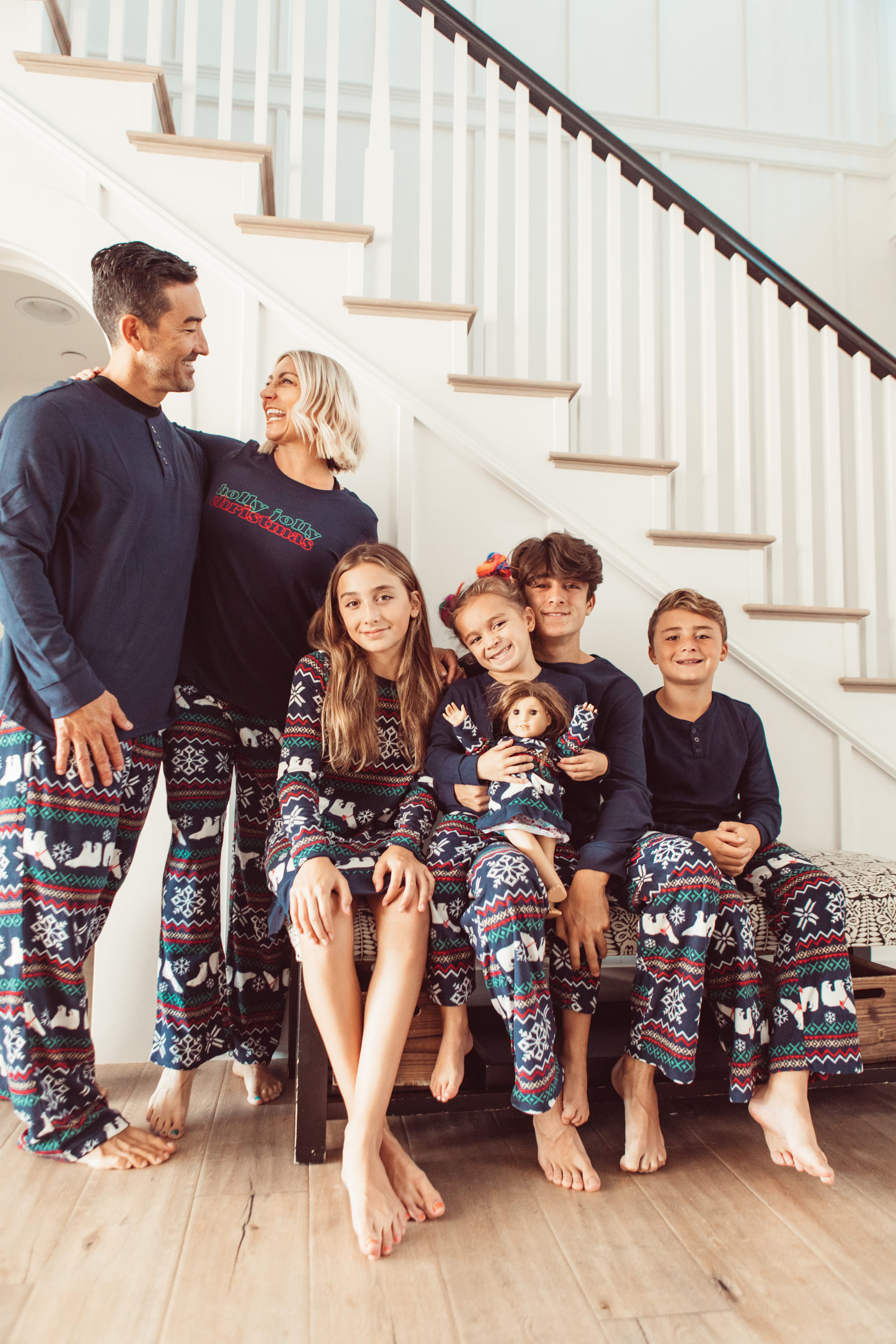 family in matching pajamas by staircase