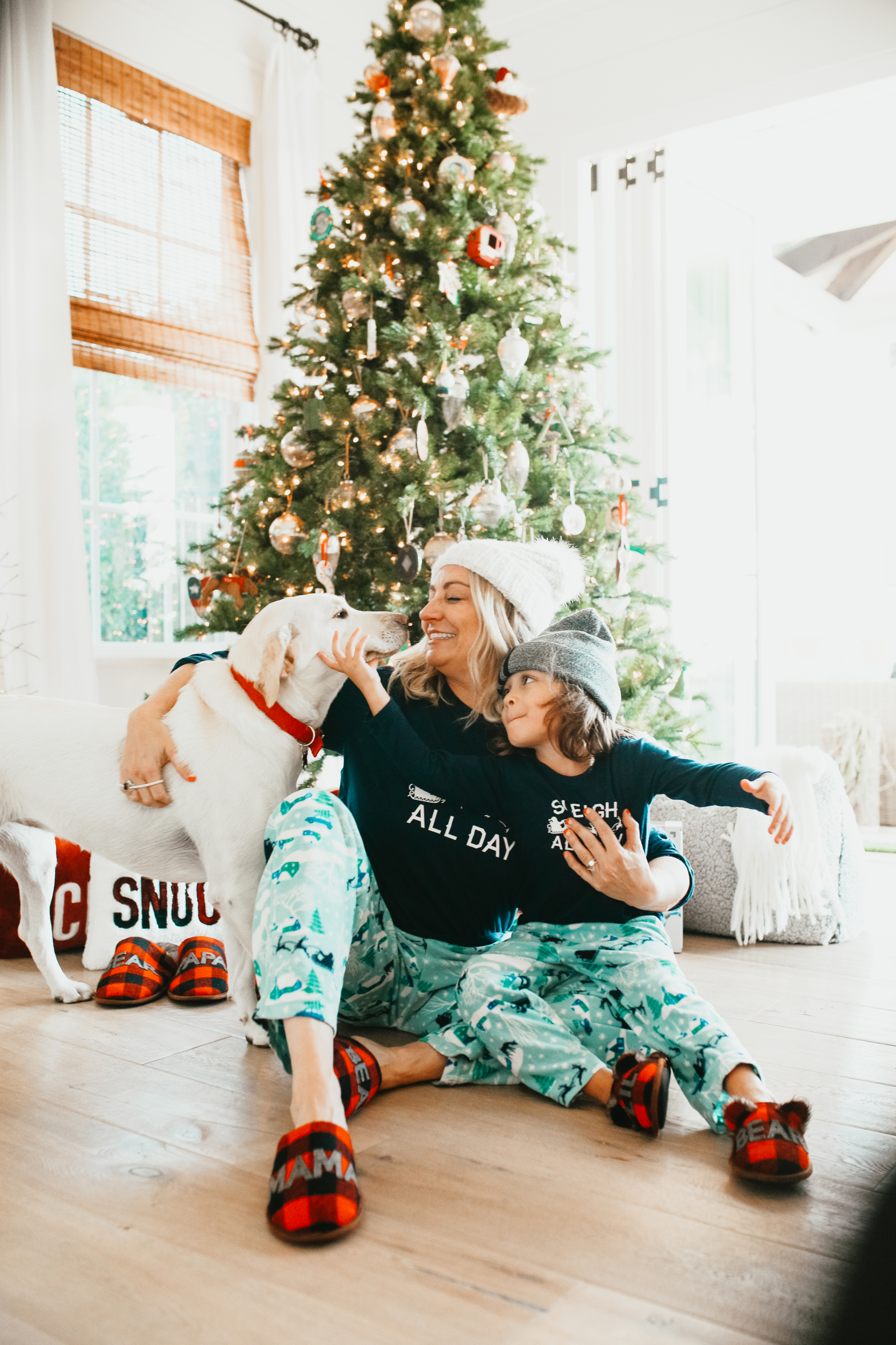 mom with son and dog under christmas tree