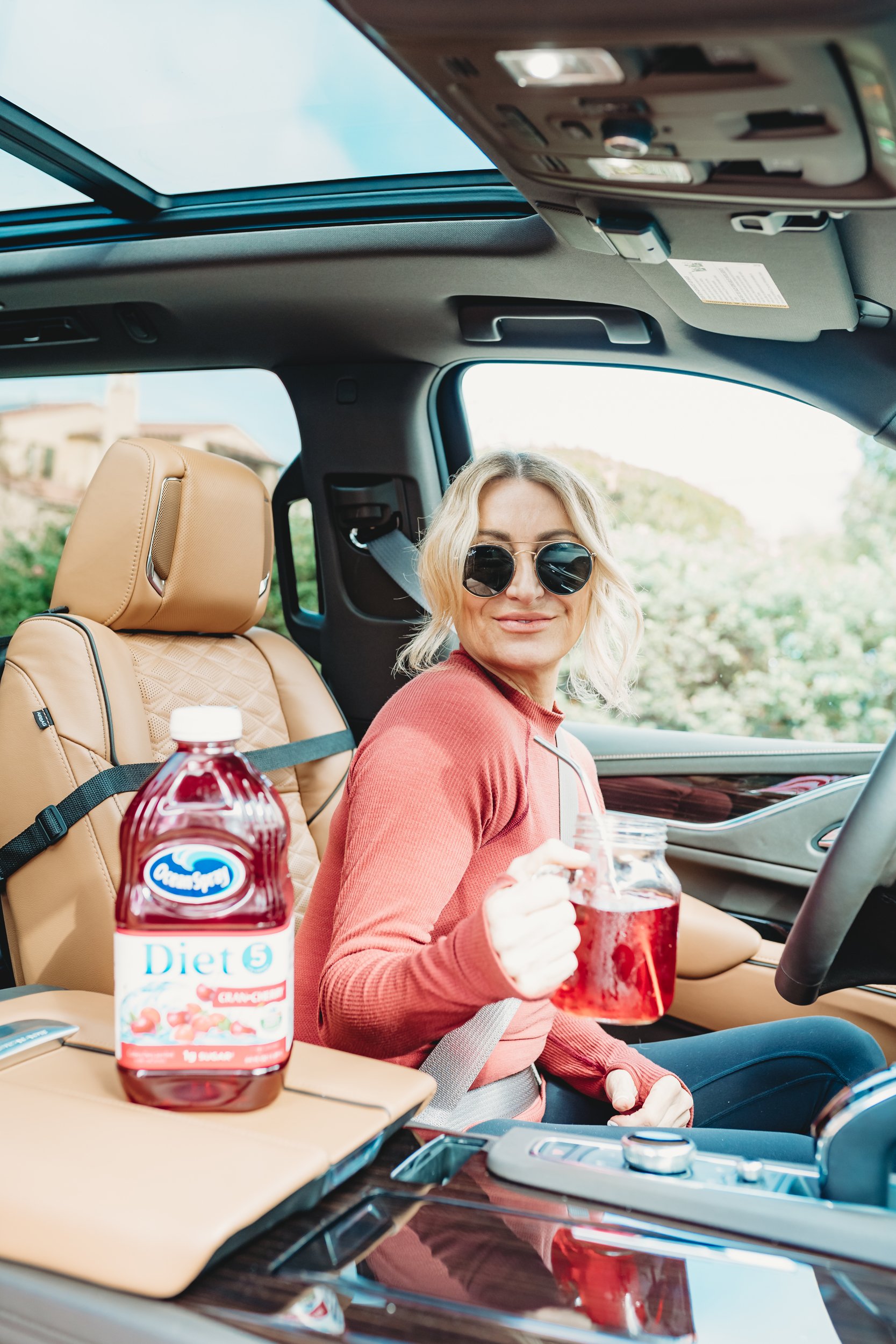 woman in car drinking juice