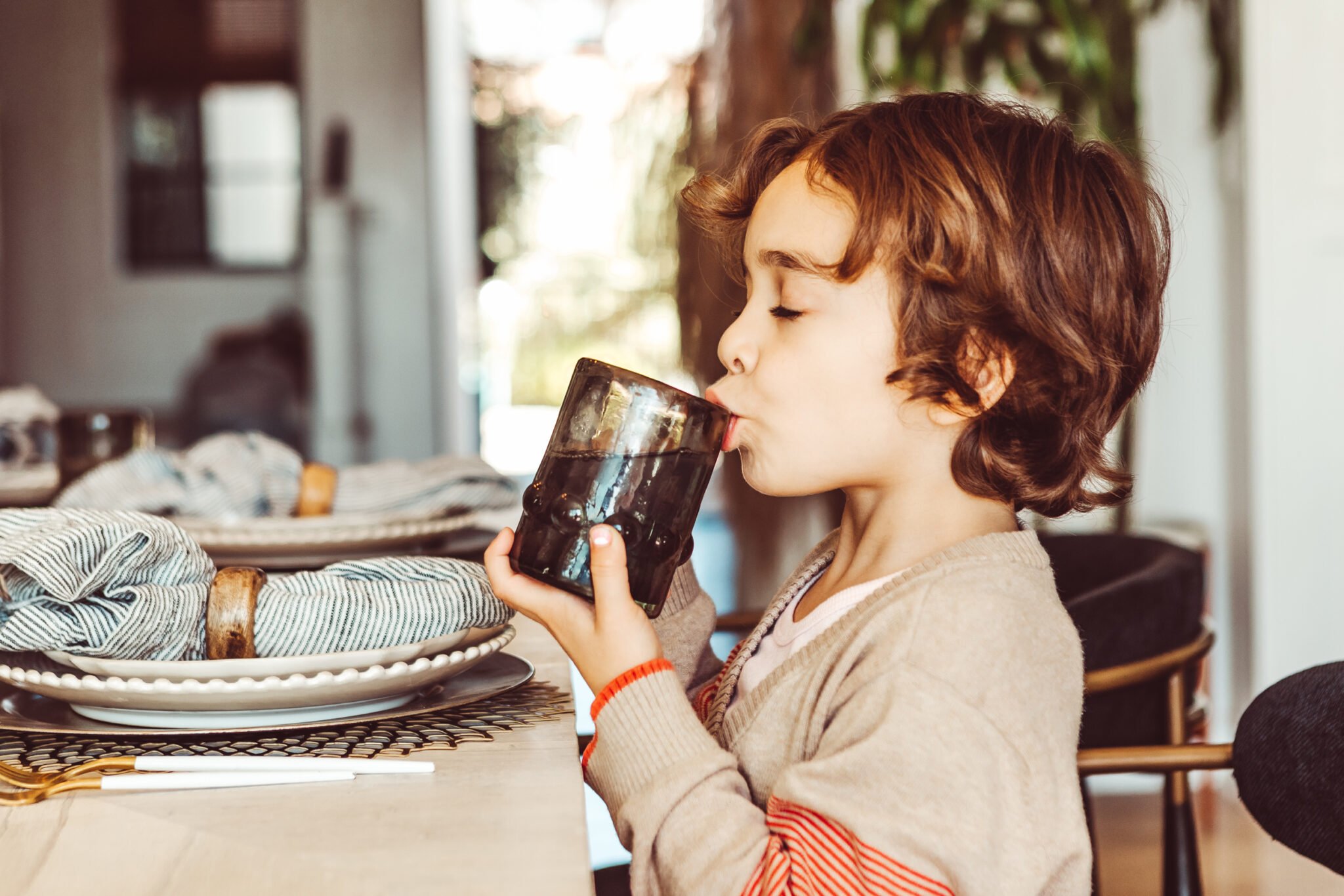 boy drinking water at table