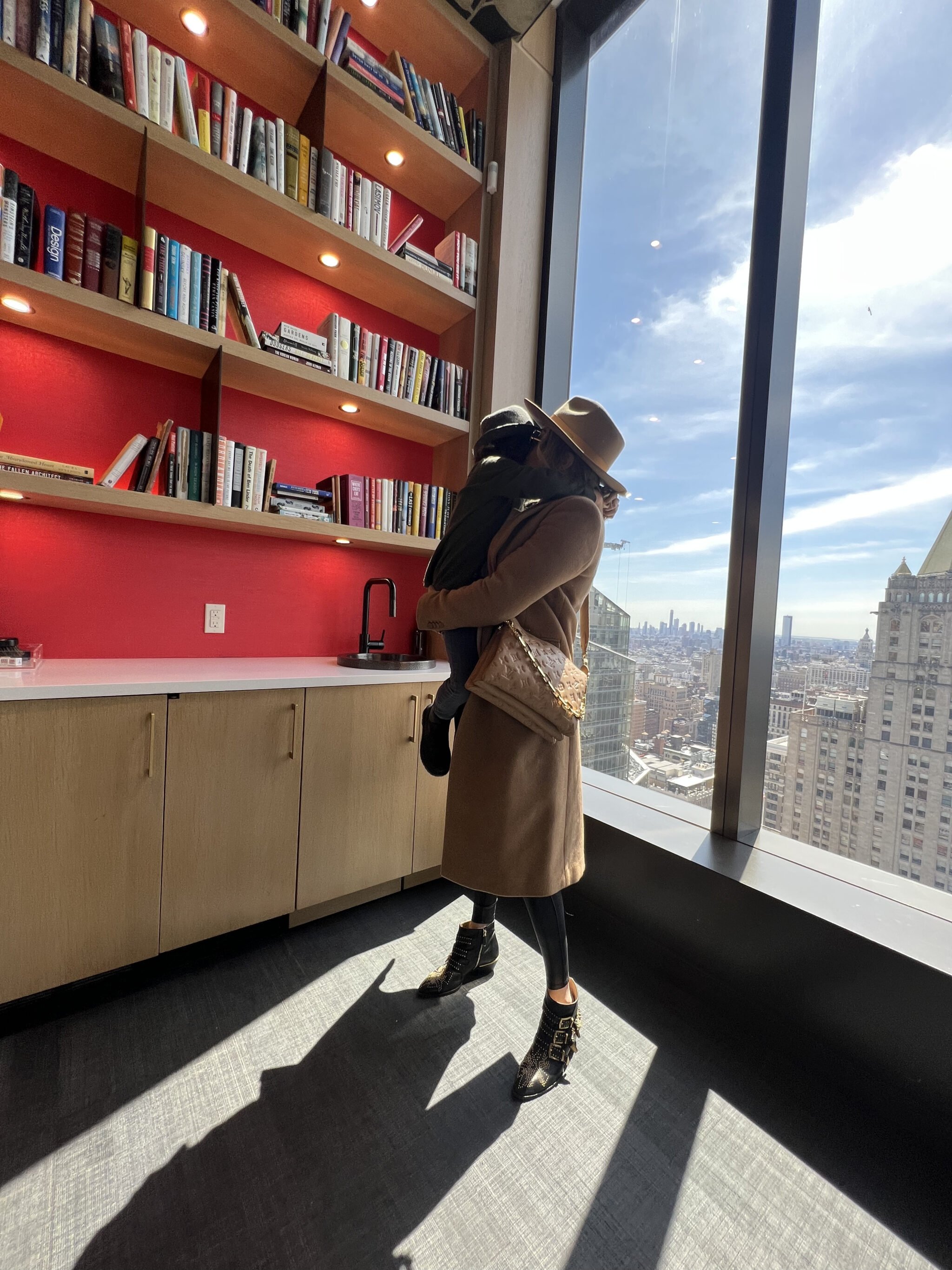 mom holding toddler by window