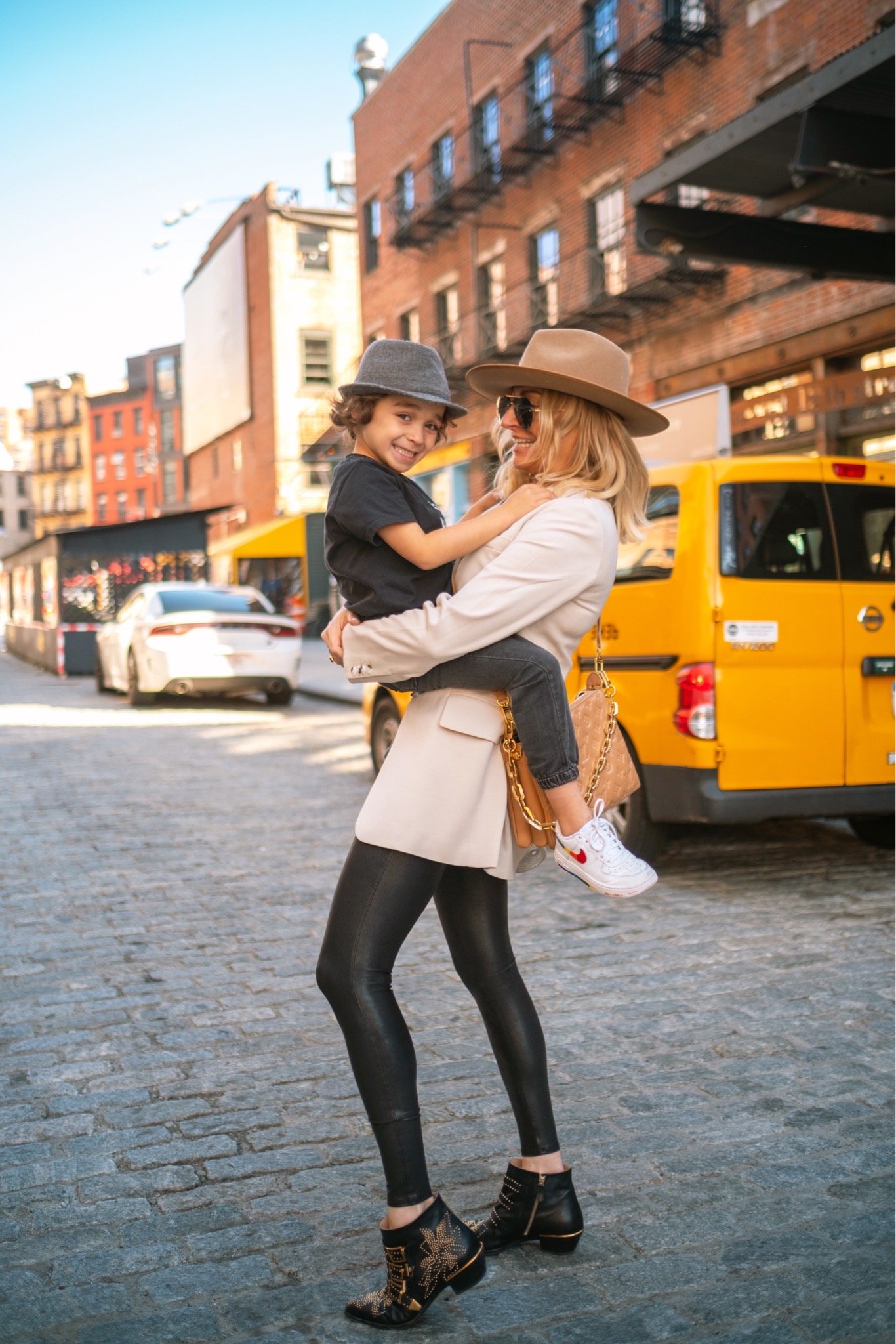mom holding toddler in city street