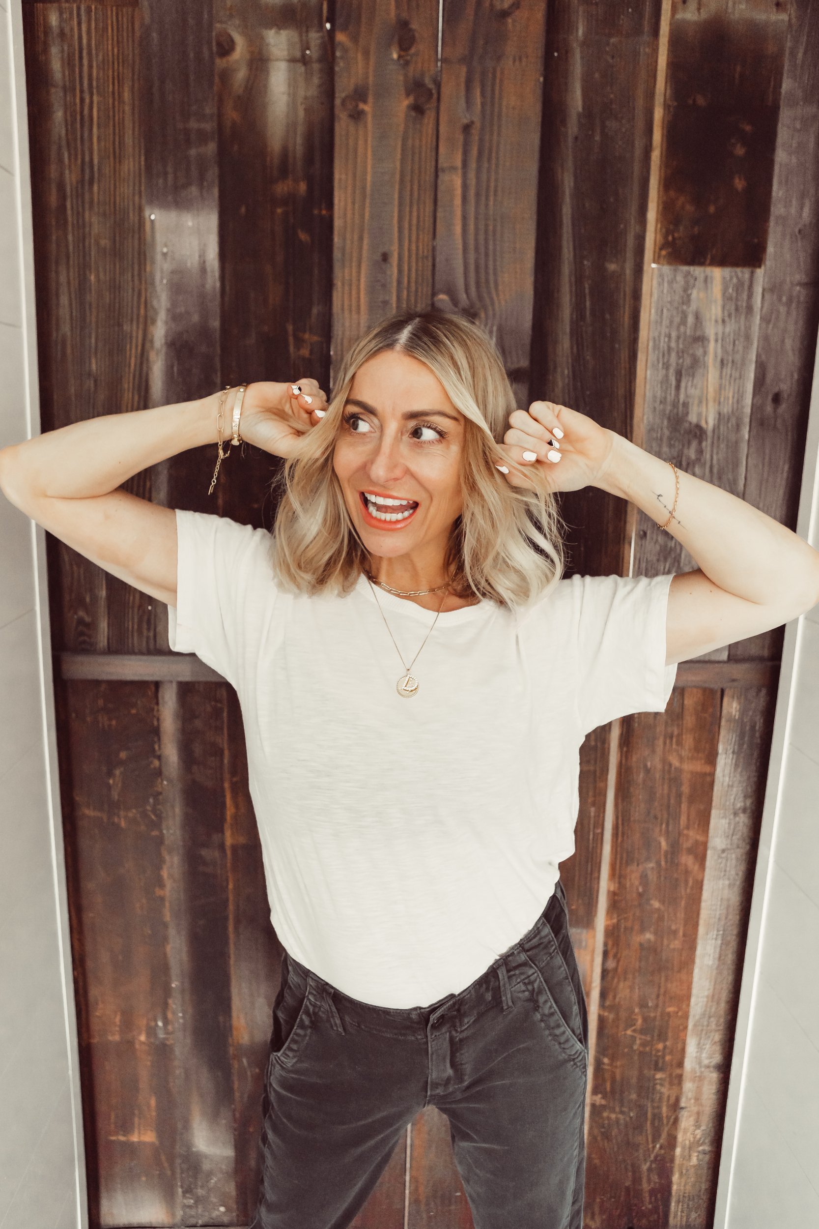 woman smiling with her hands on her head