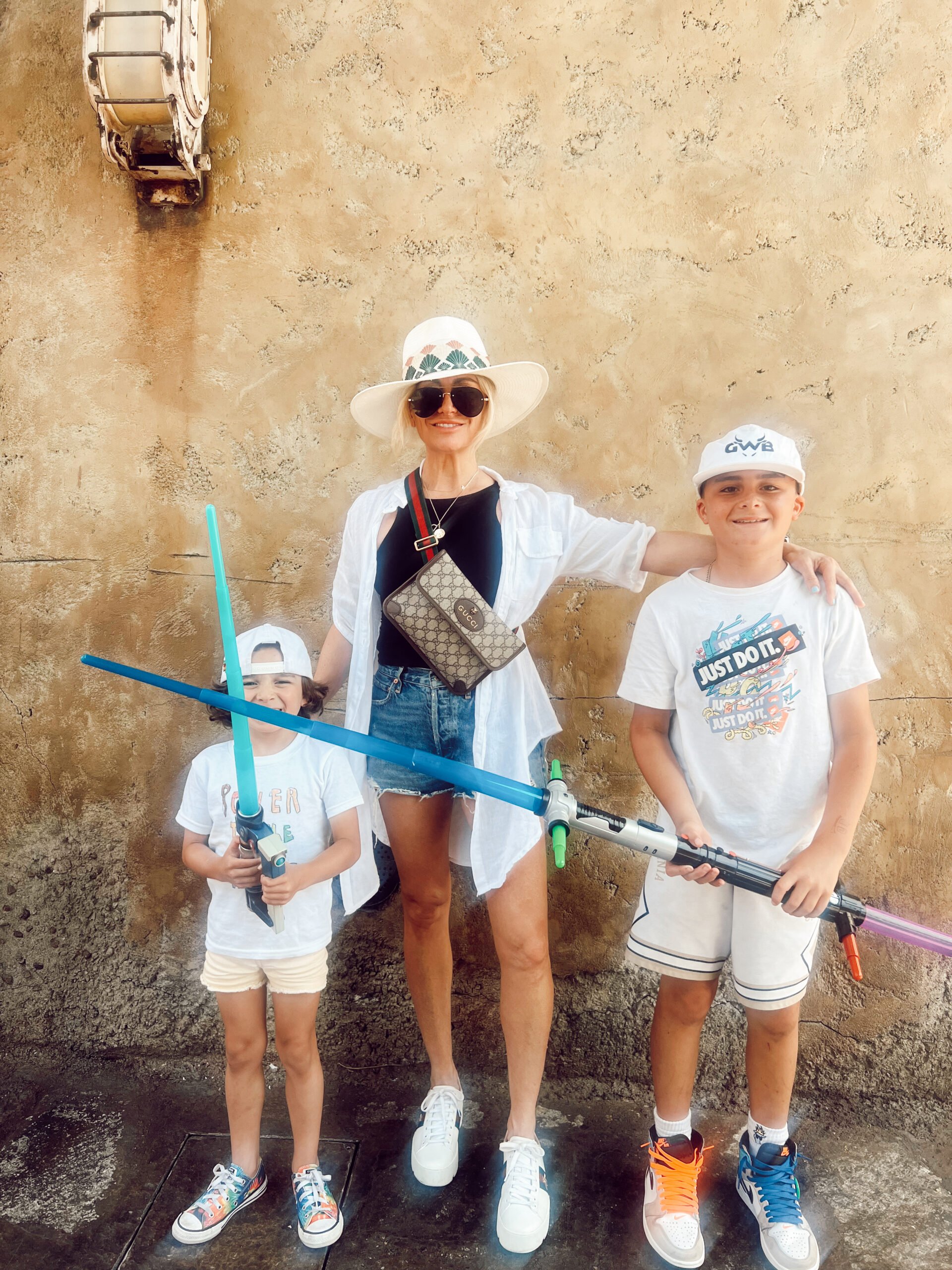 mom with boys holding lightsabers