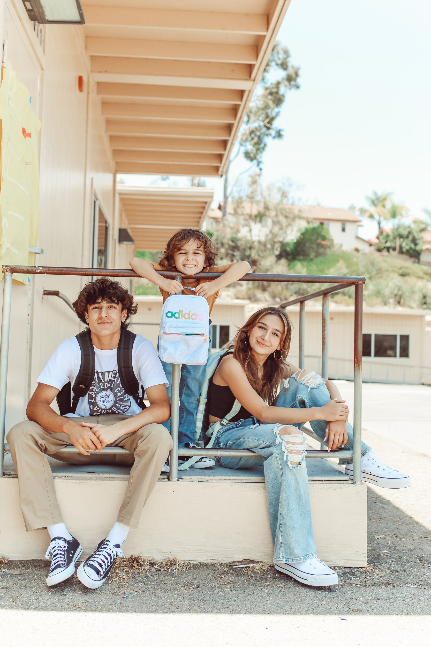 siblings sitting outside school