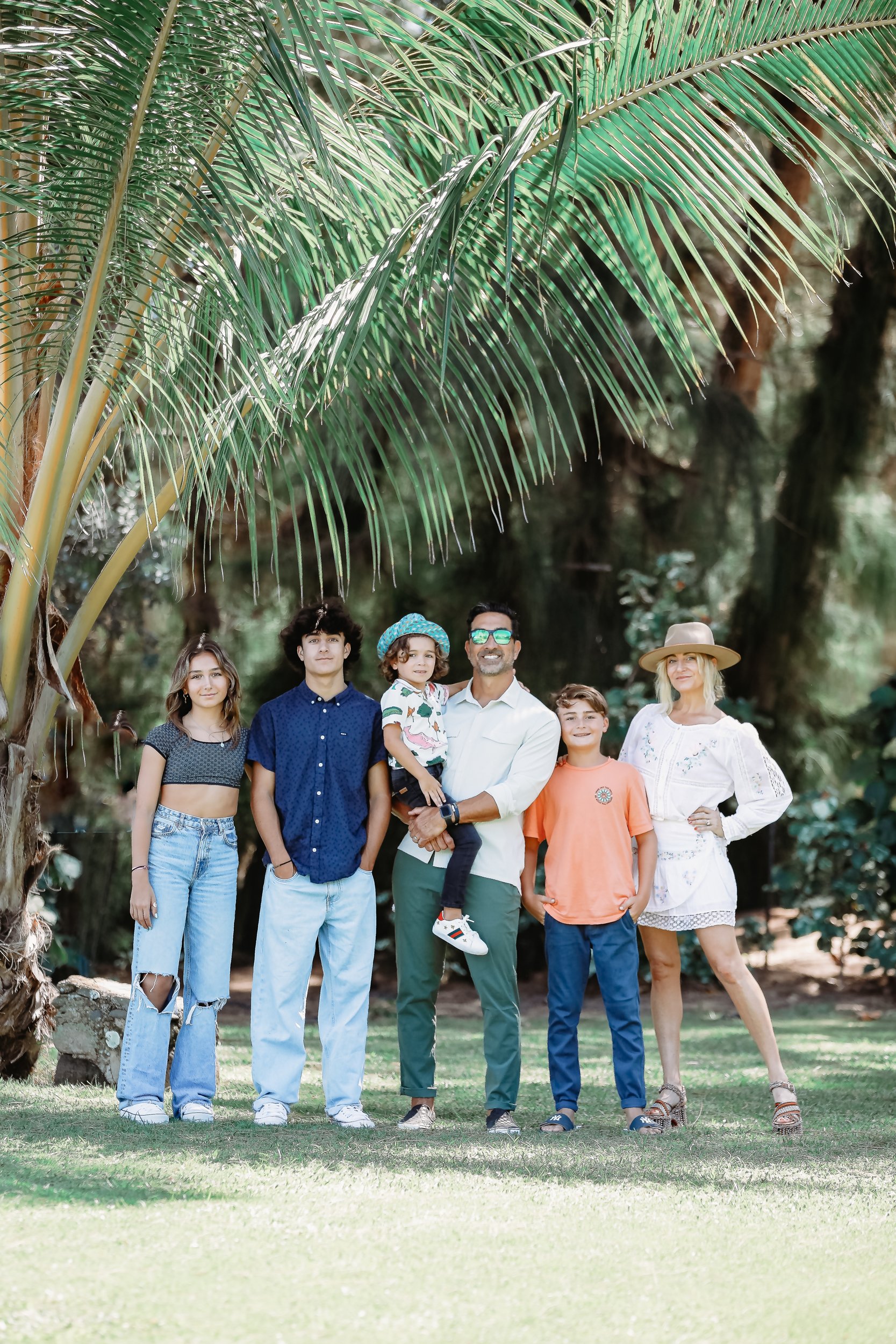 parents with kids under palm tree