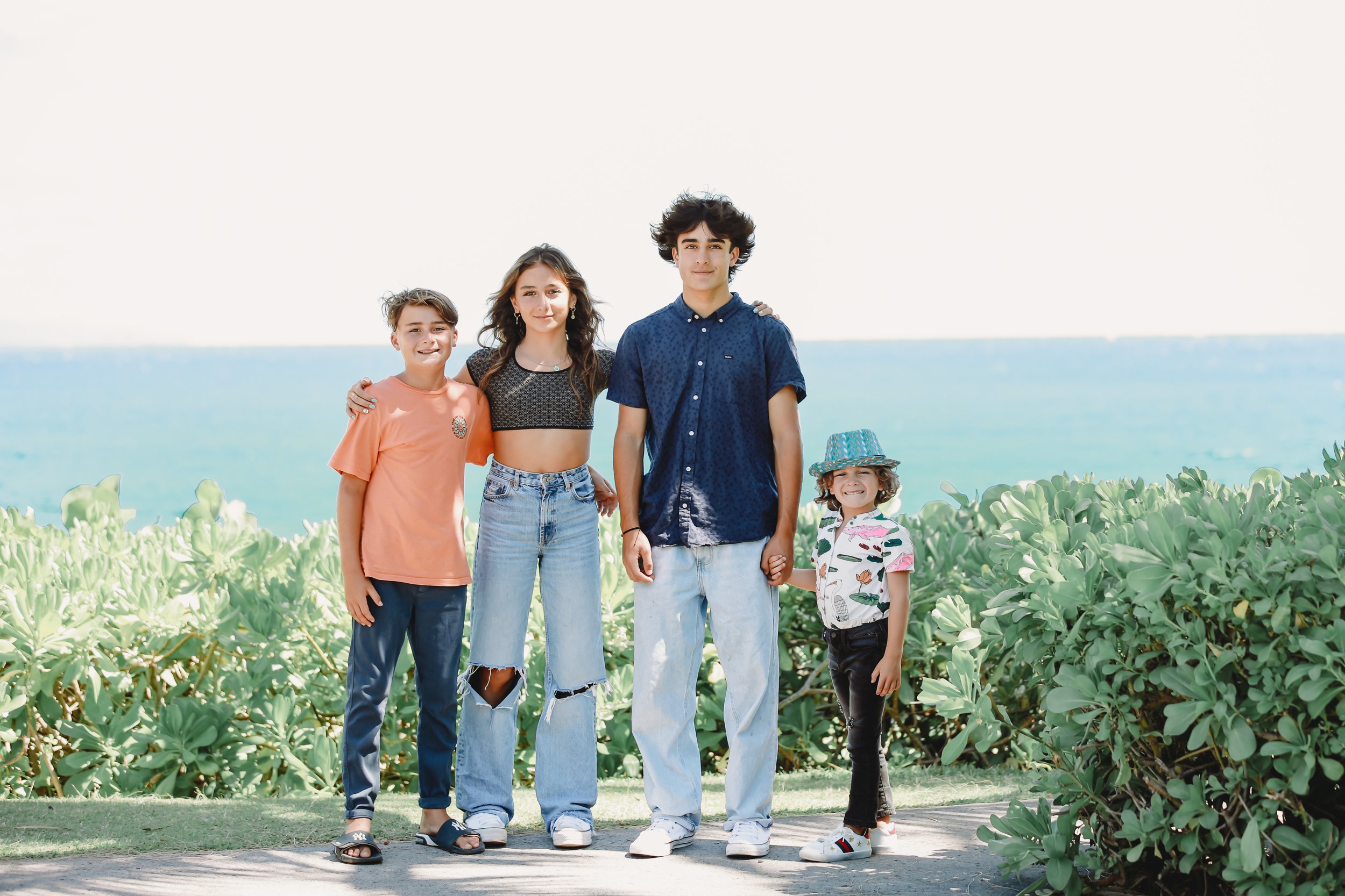 siblings standing together at the beach