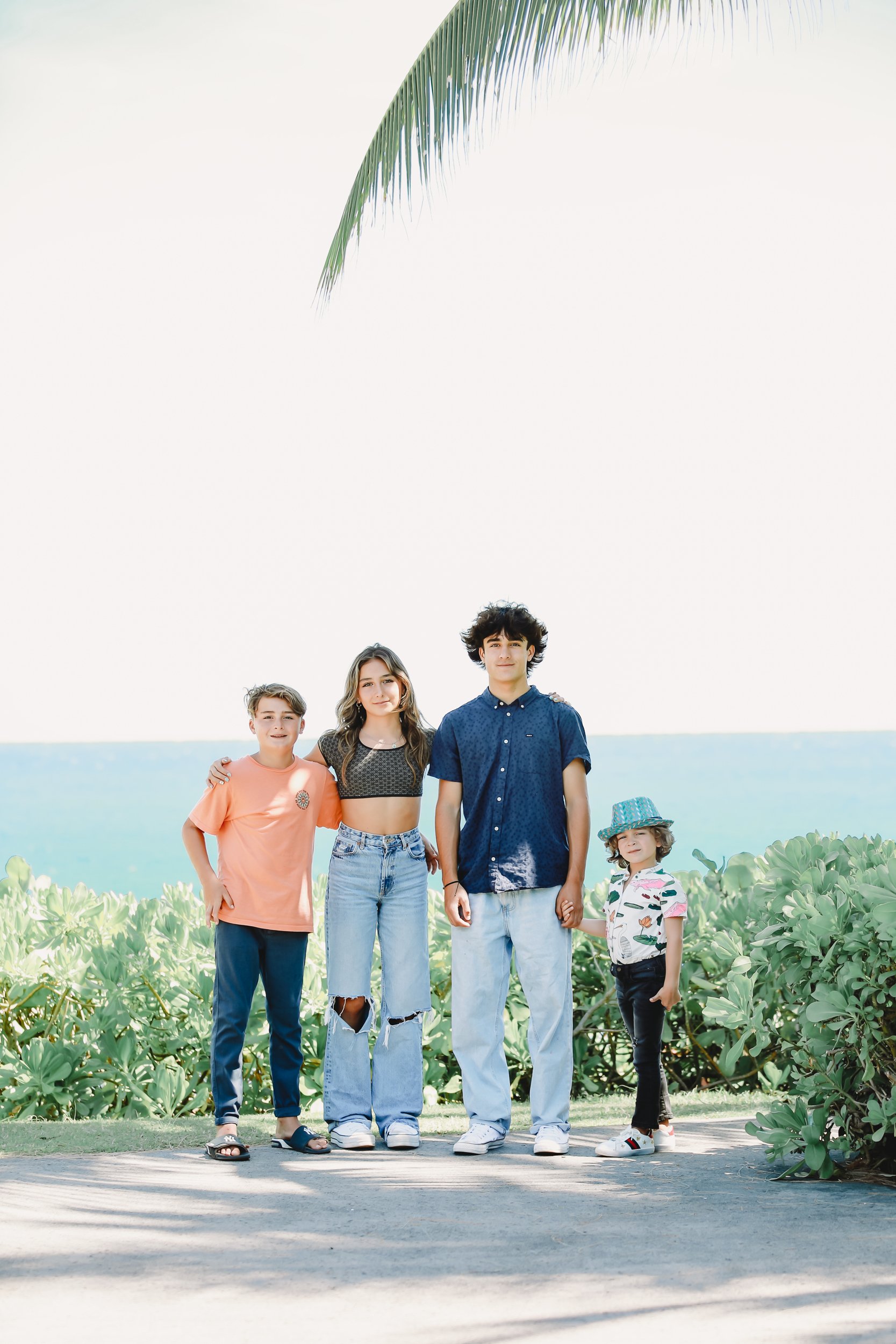 siblings standing together at the beach