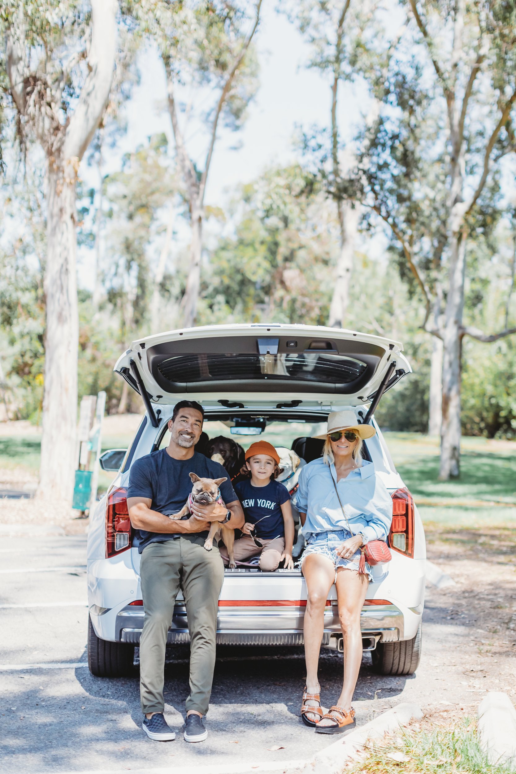 family sitting in back of suv