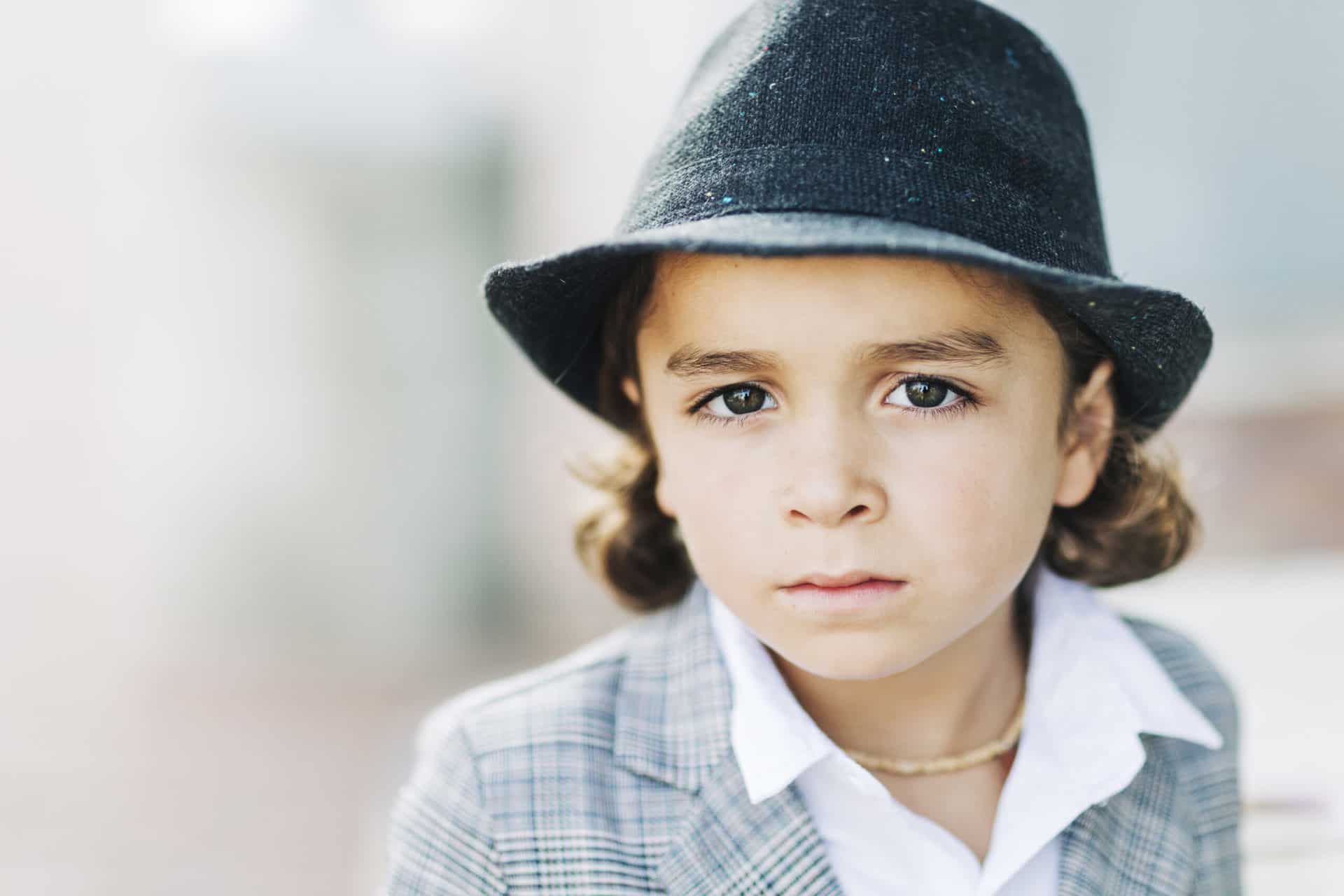 closeup of boy in suit and hat
